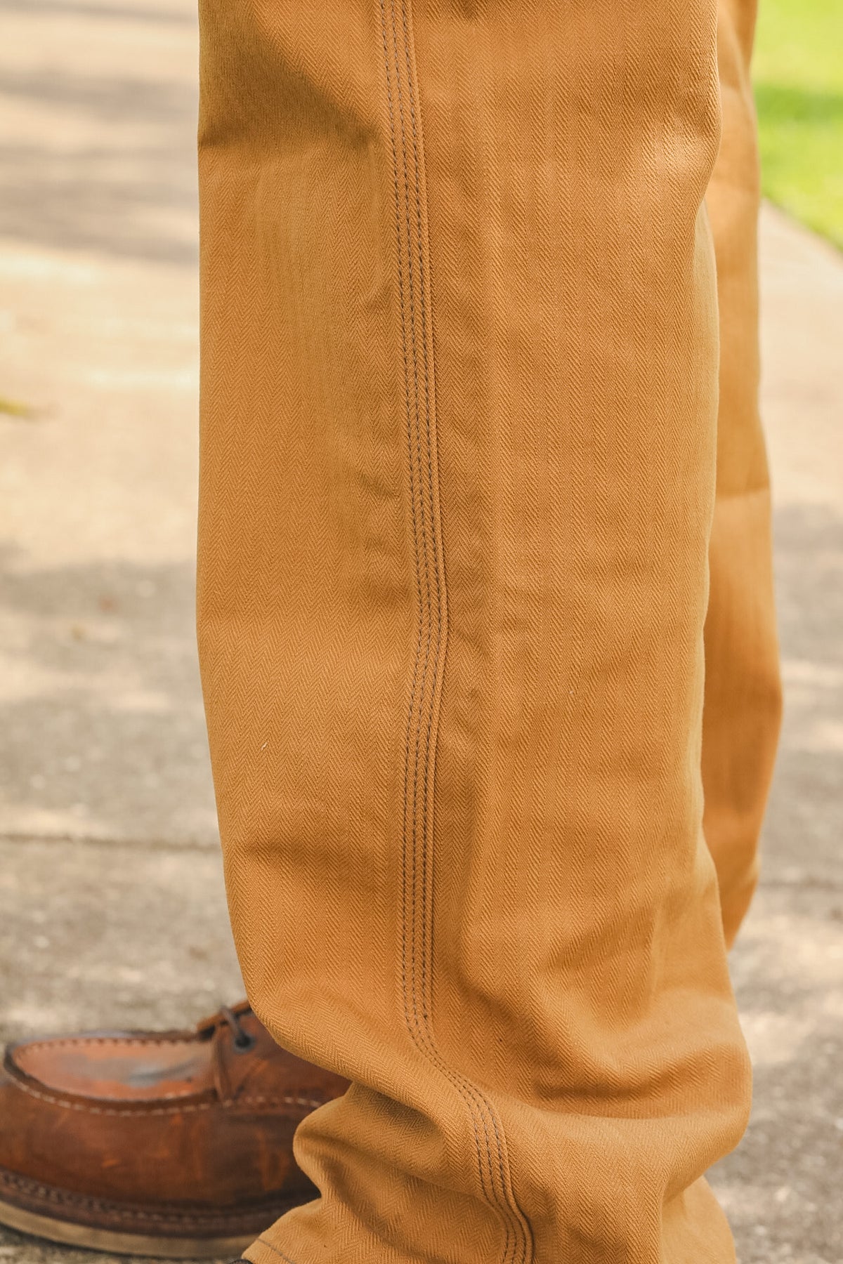 Close-up of brown pants with a blurred outdoor background