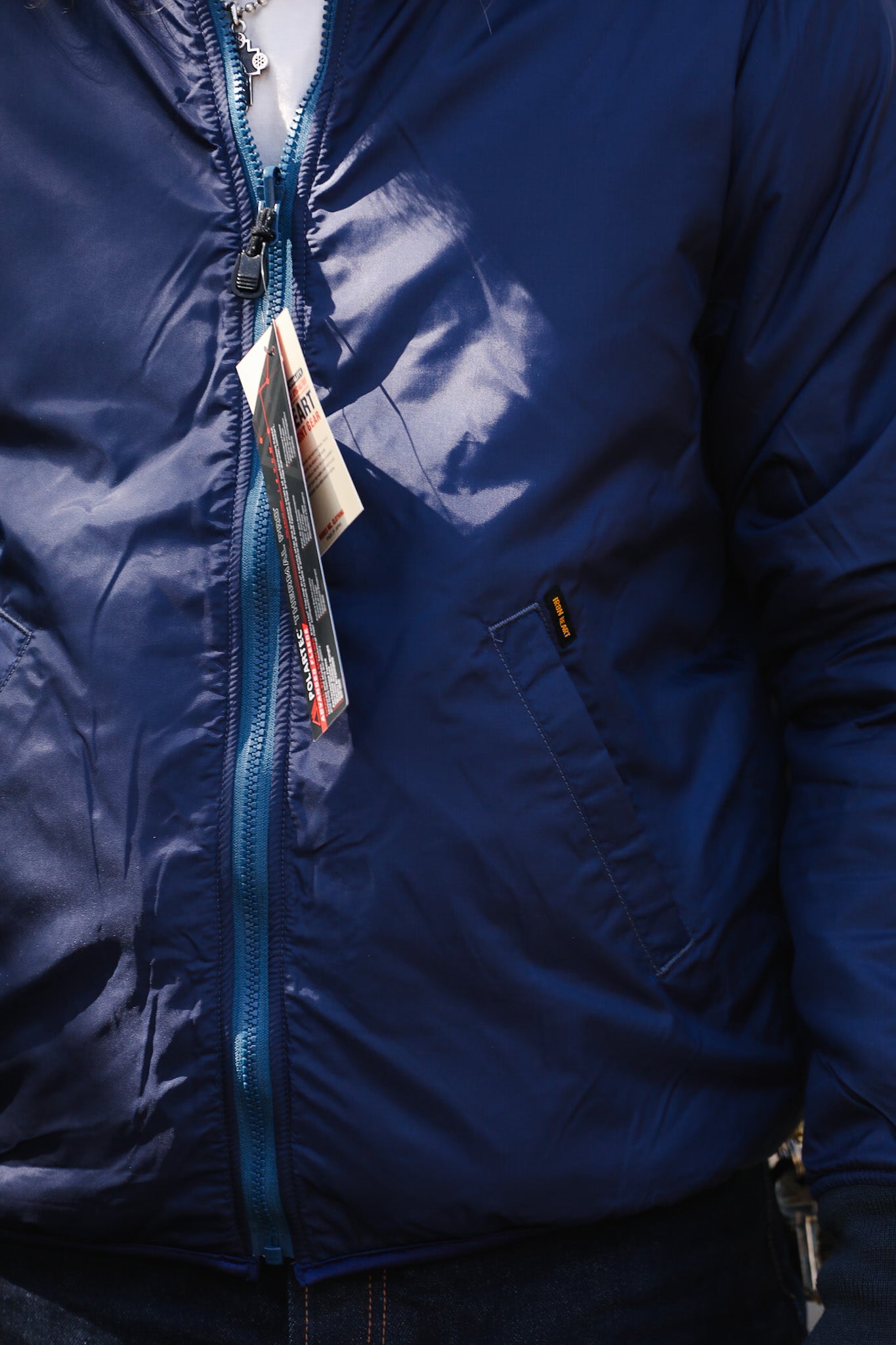 Close-up of a blue jacket with a card sticking out of the pocket