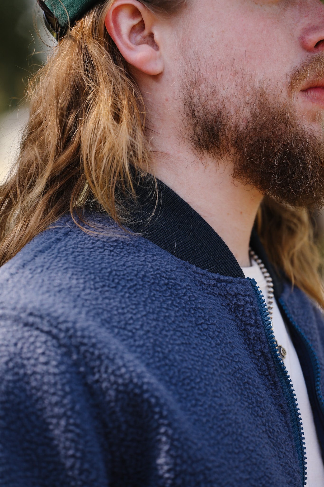 Close-up of a person wearing a blue fleece jacket with a blurred background