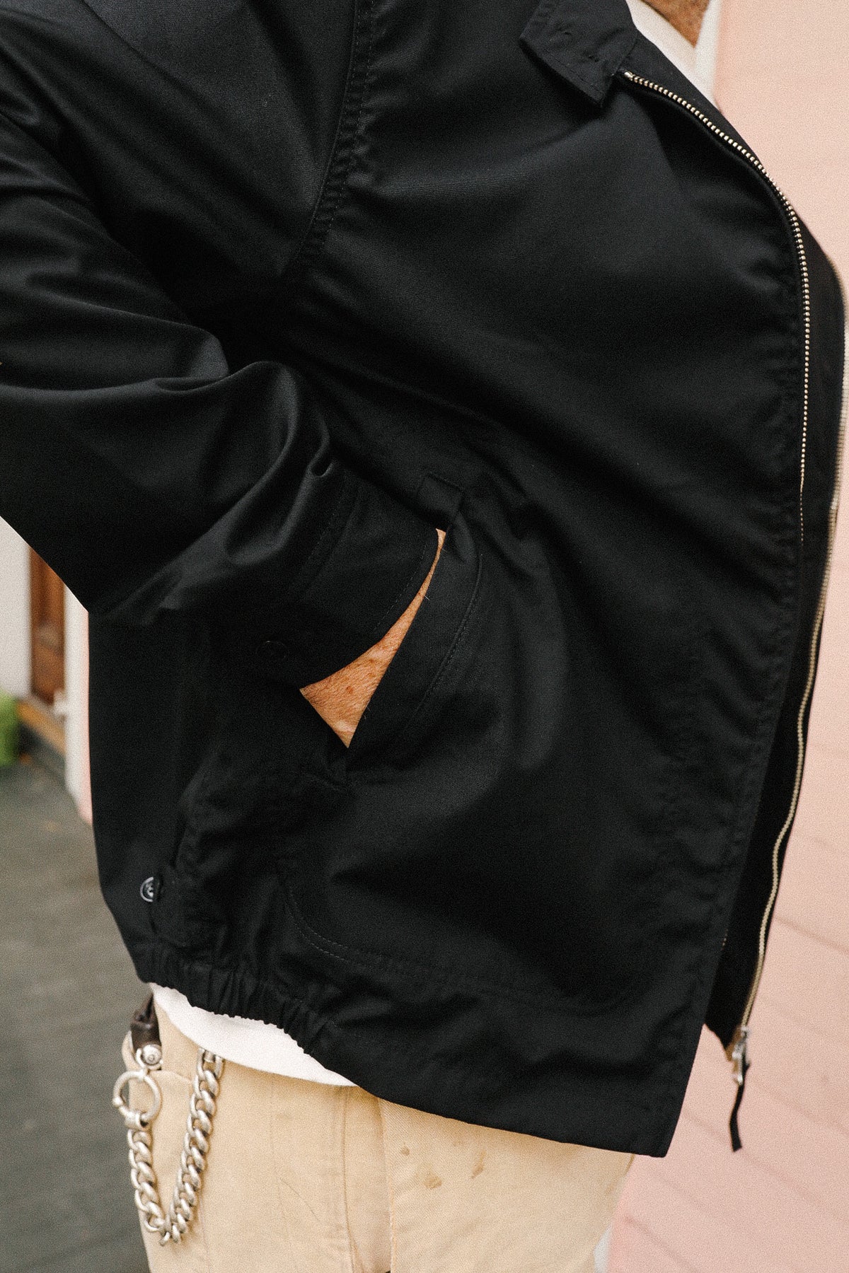 Close-up of a person wearing a black jacket with a blurred background
