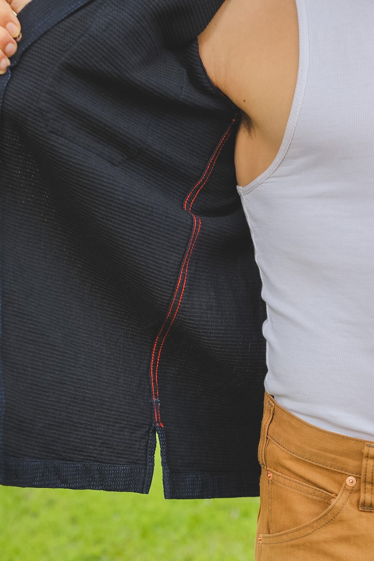 Two people standing close together with a focus on their clothing against a blurred background.