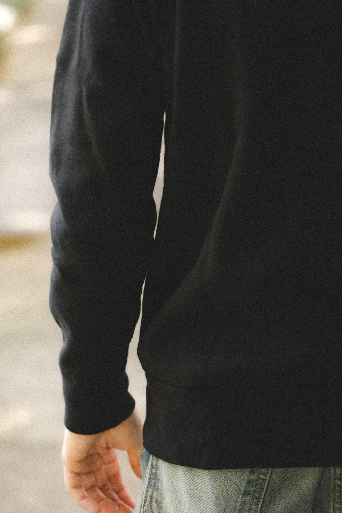 Person wearing a black hoodie with a blurred background