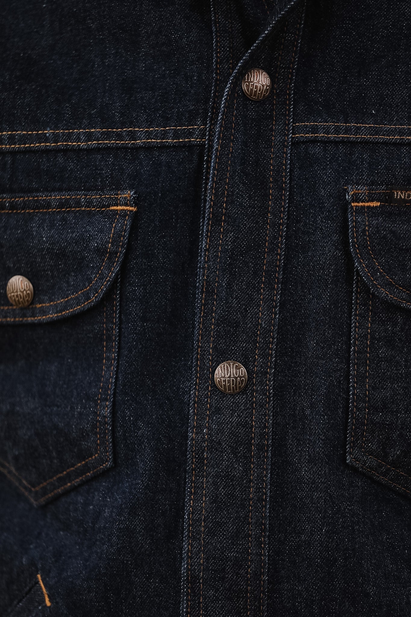 Close-up of a dark denim jacket with button details