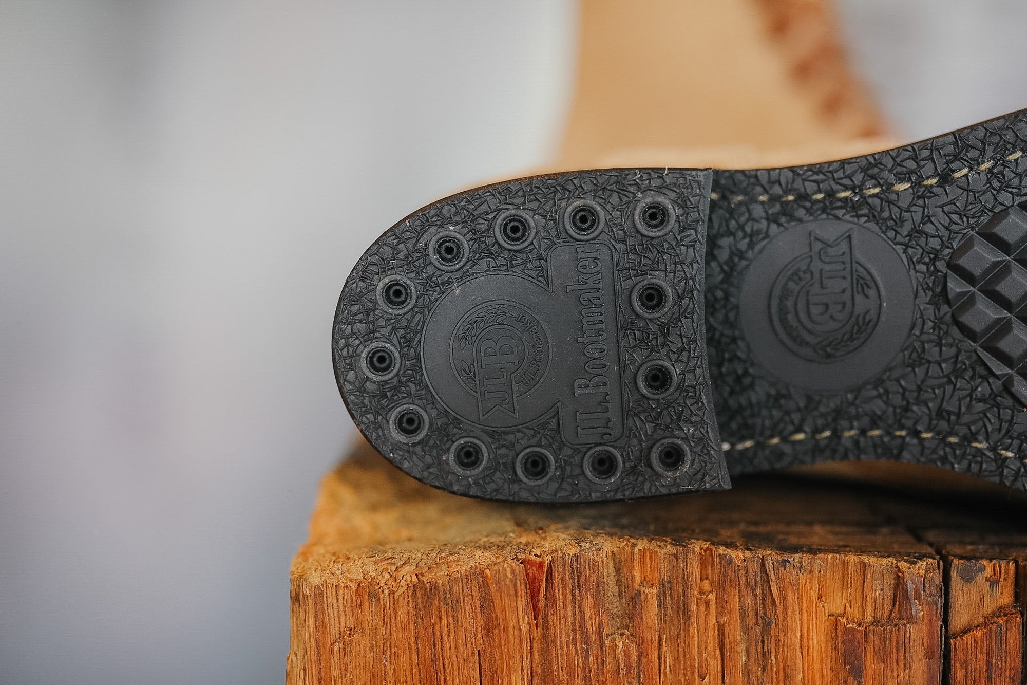 Close-up of a shoe sole with brand logo on a wooden block