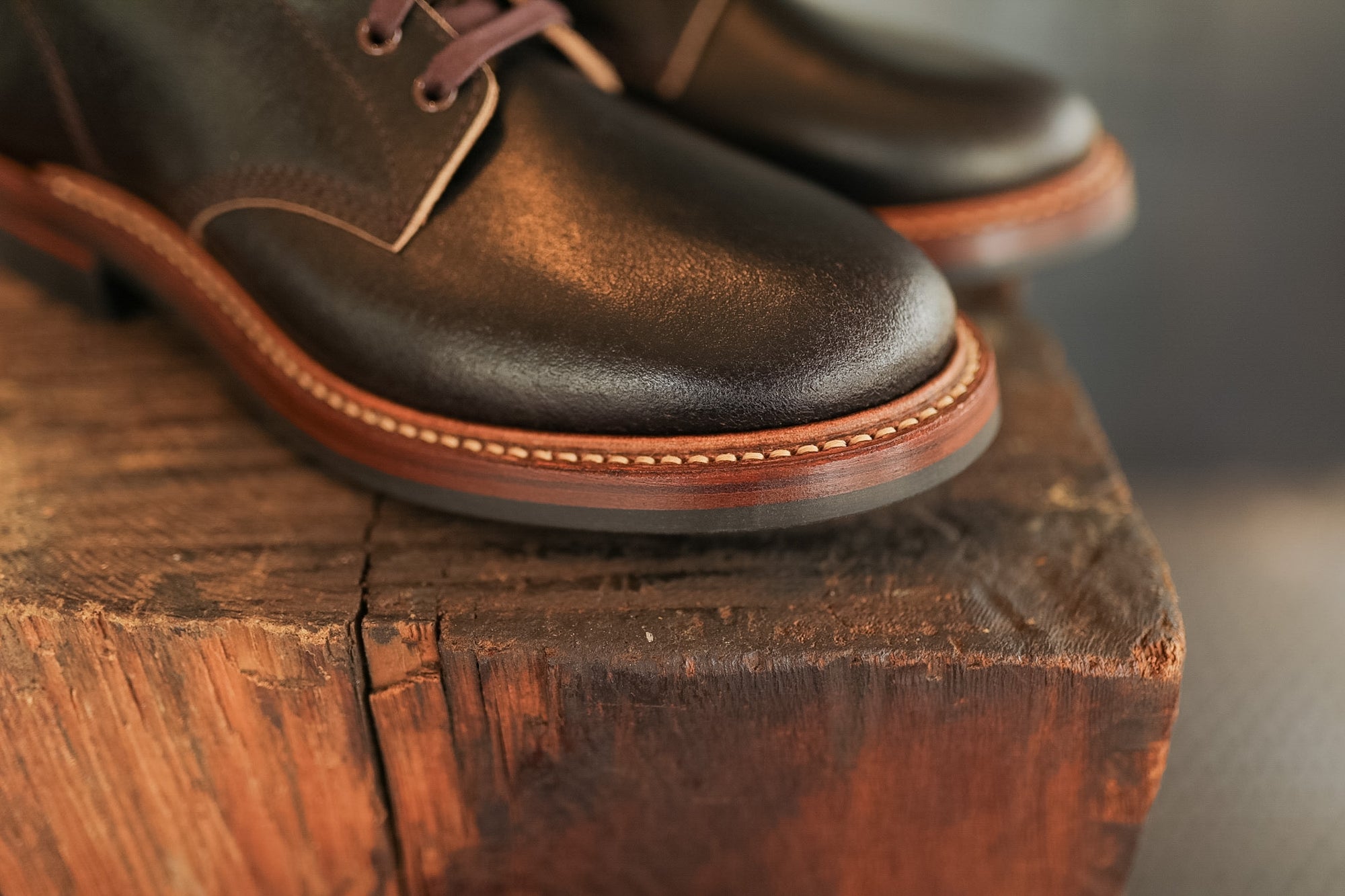 Pair of brown leather shoes on a wooden surface with a blurred background