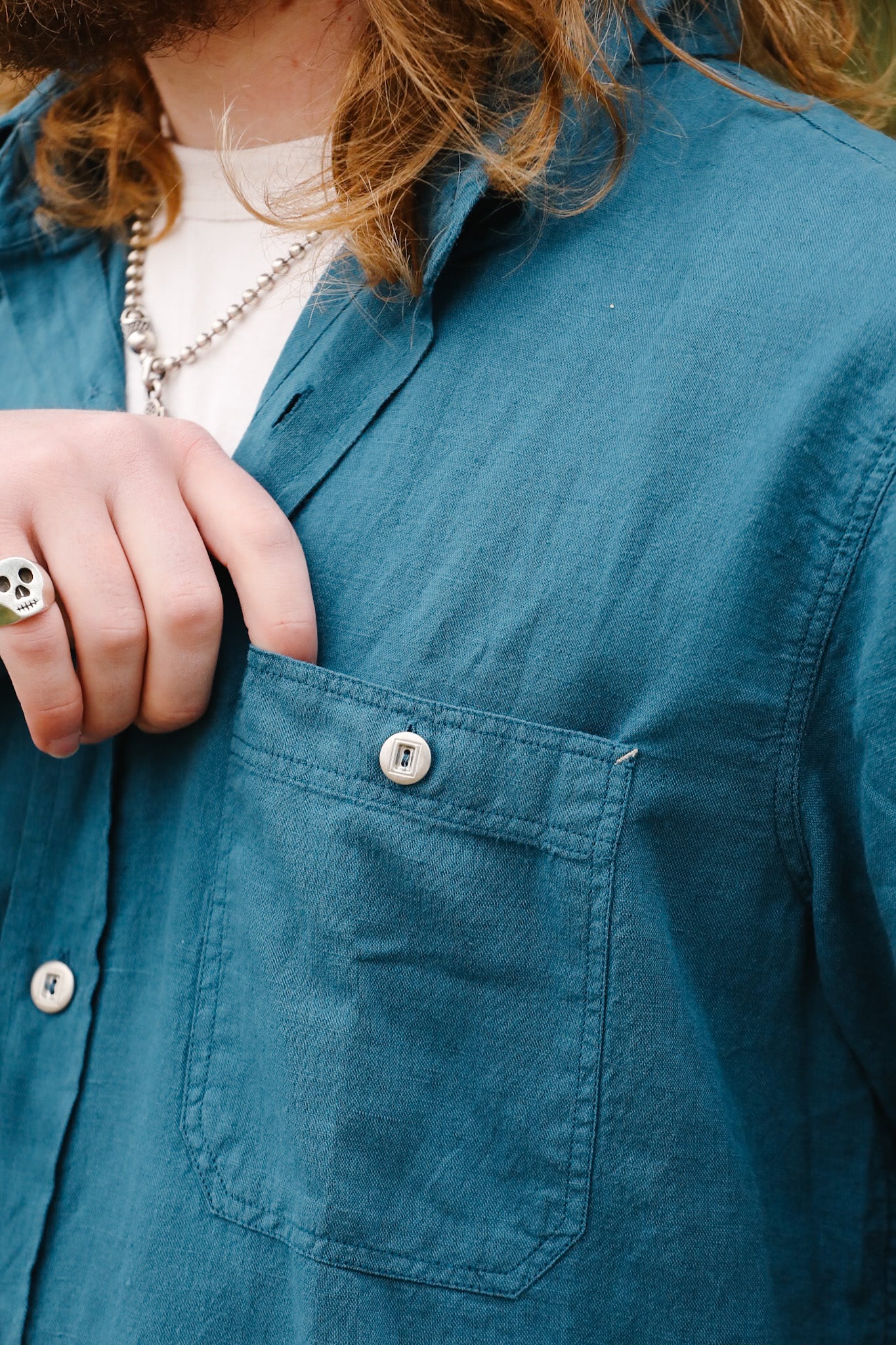 Close-up of a person wearing a blue jacket with a pocket, focusing on the collar and chest area.