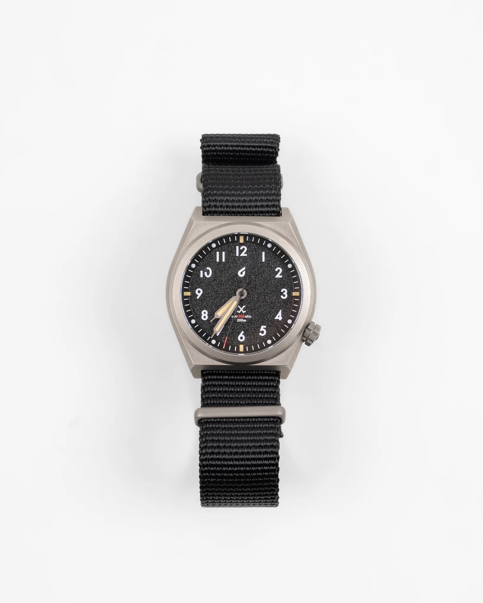 Autoglatic Field Watch with black dial, beige hands, titanium case, and black nylon strap on white background