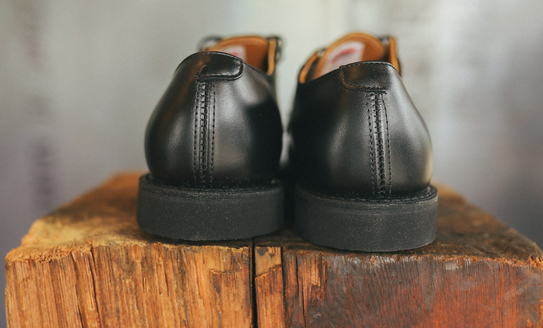 Back view of black Postman Oxford leather shoes on rustic wooden surface at Iron Shop Provisions