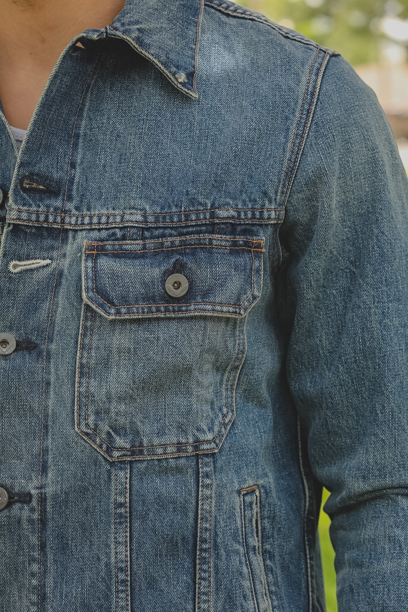 Close-up of a blue denim jacket with a blurred background