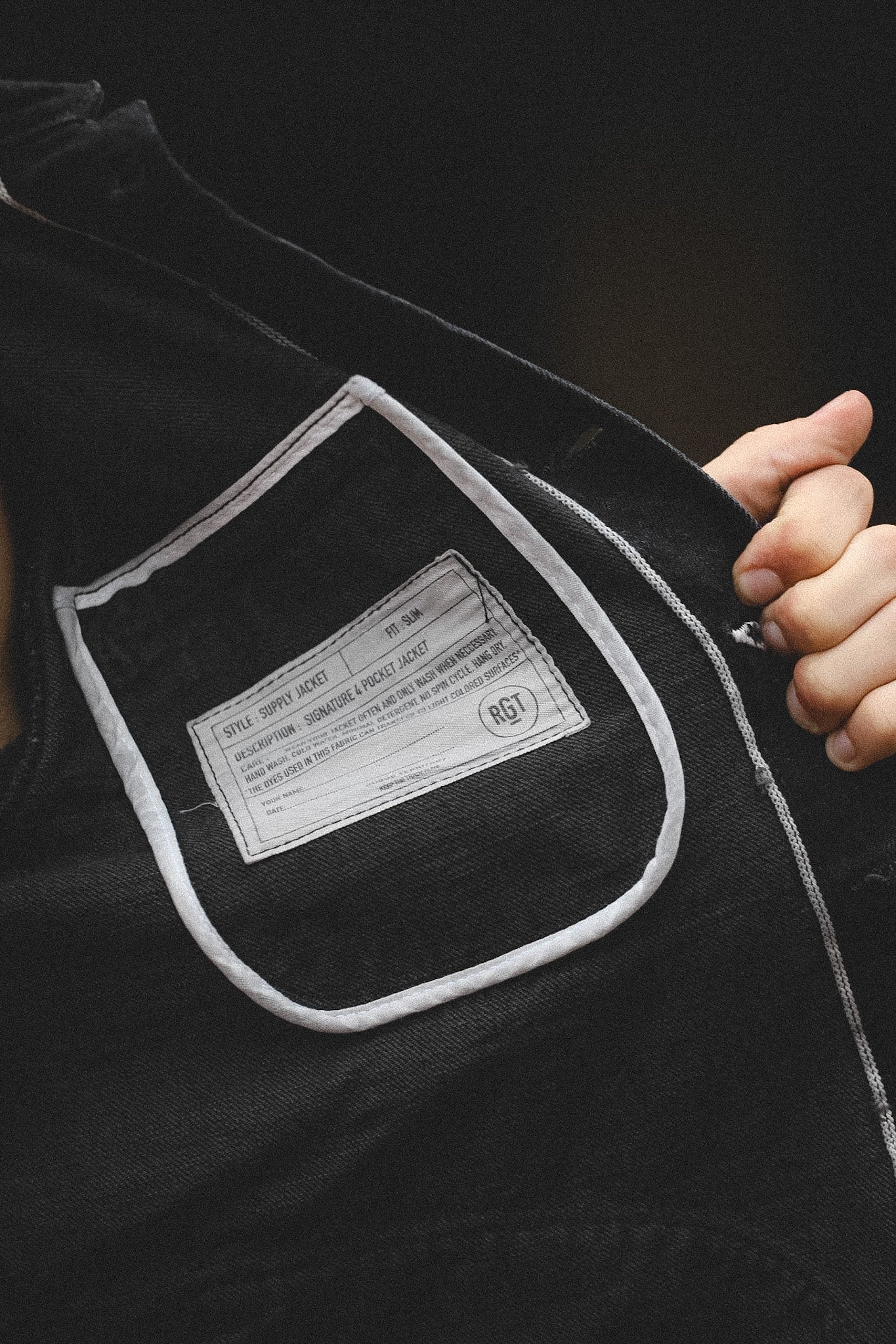 Close-up of a label on a black garment with a dark background