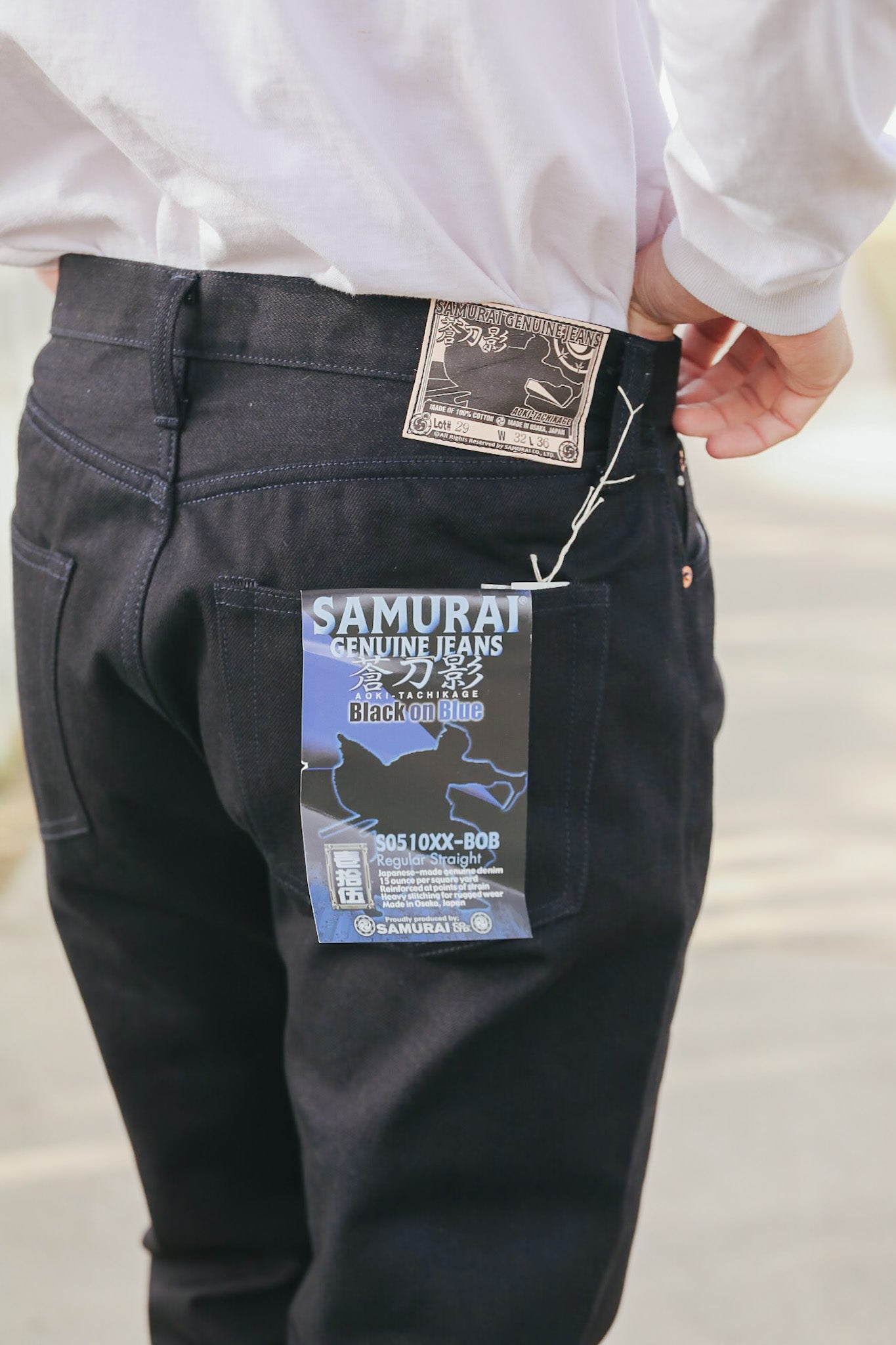 Black jeans with Samurai Jeans label on a plain background