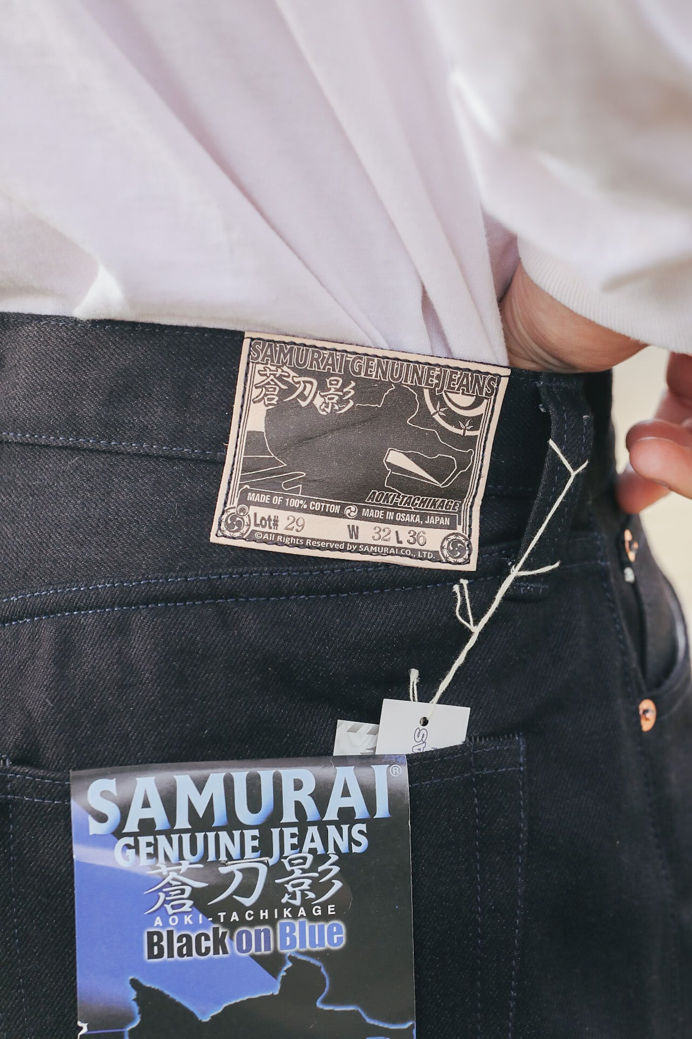 Close-up of Samurai Genuine Jeans label on a black denim pocket.
