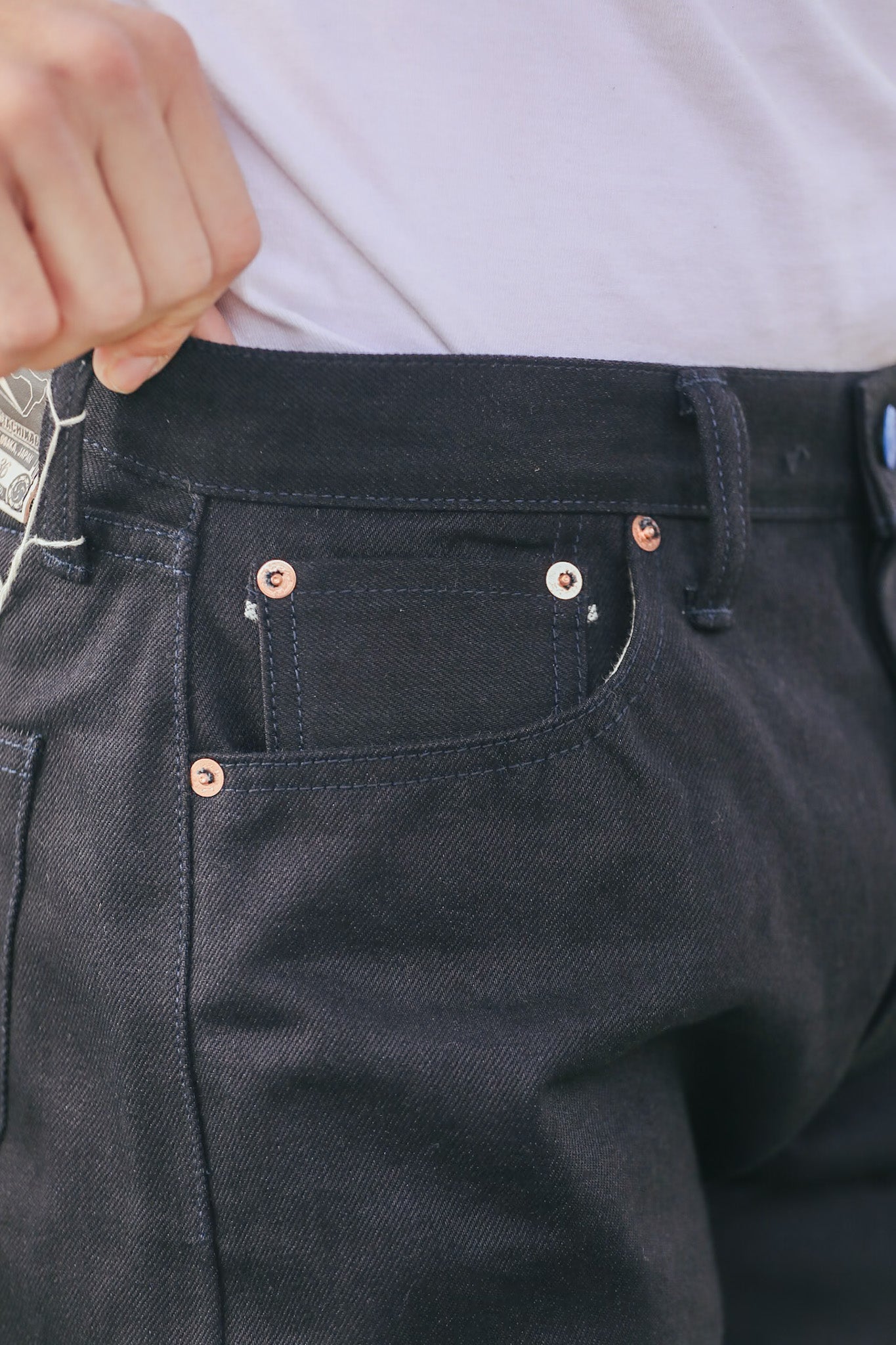 Close-up of dark blue jeans with visible stitching and buttons.