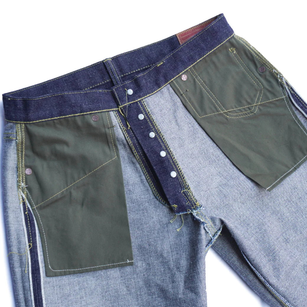Inside view of heavy denim jeans with green reinforced workwear pockets and button fly closure
