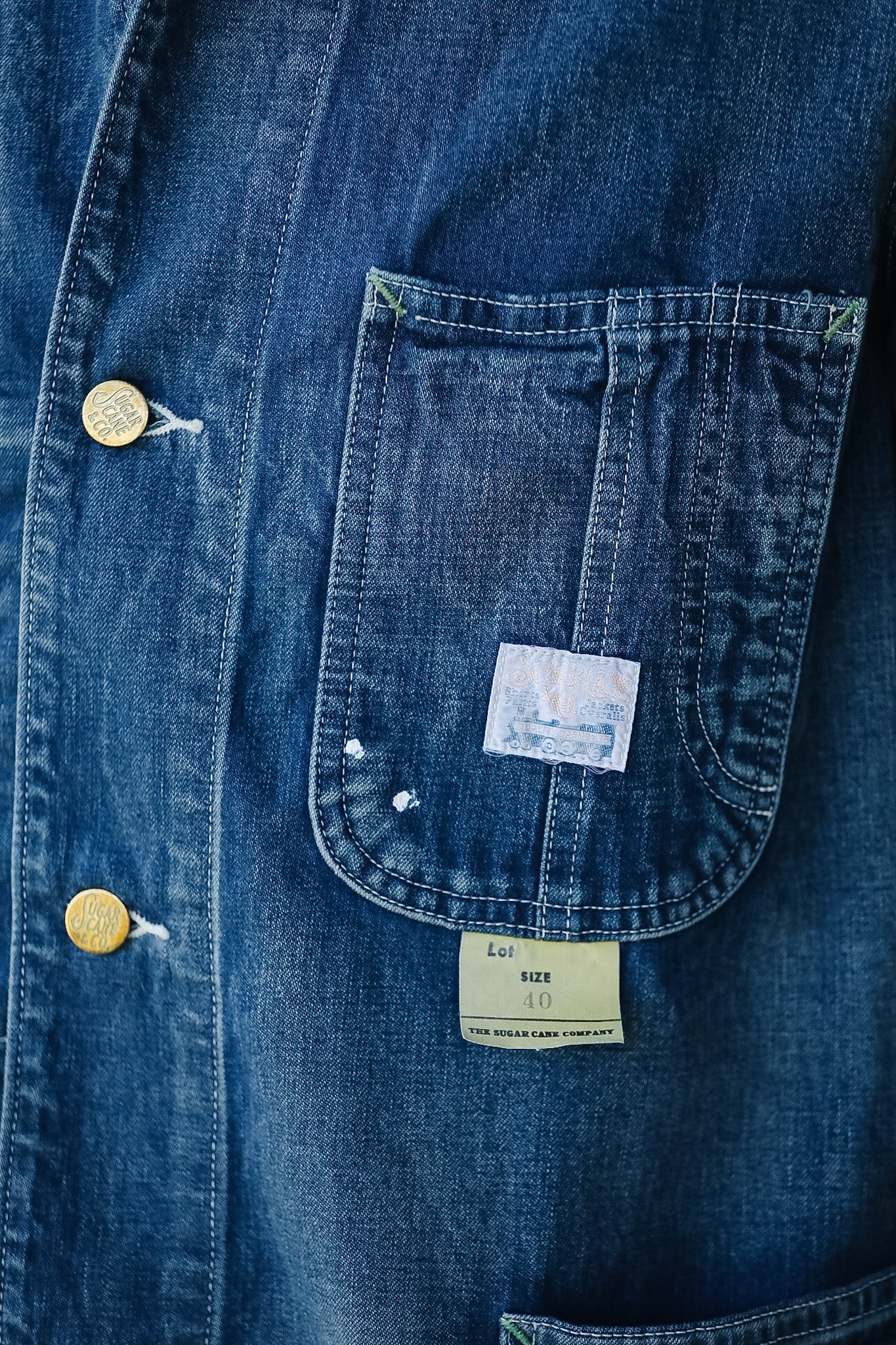 Close-up of a blue denim shirt with a pocket and visible brand label.