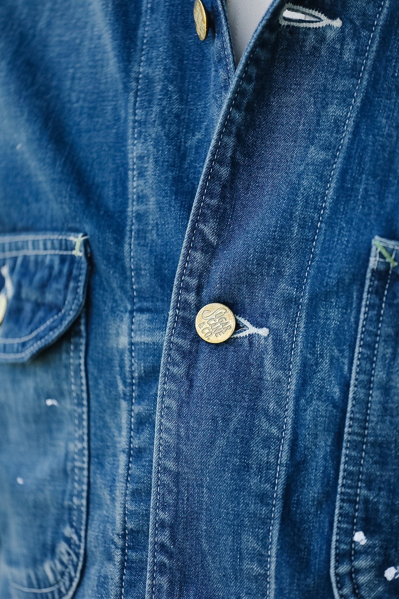 Close-up of a blue denim shirt with buttons and a pocket.
