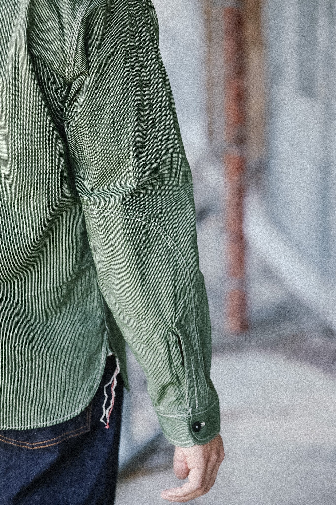 Person wearing a green jacket with a blurred background