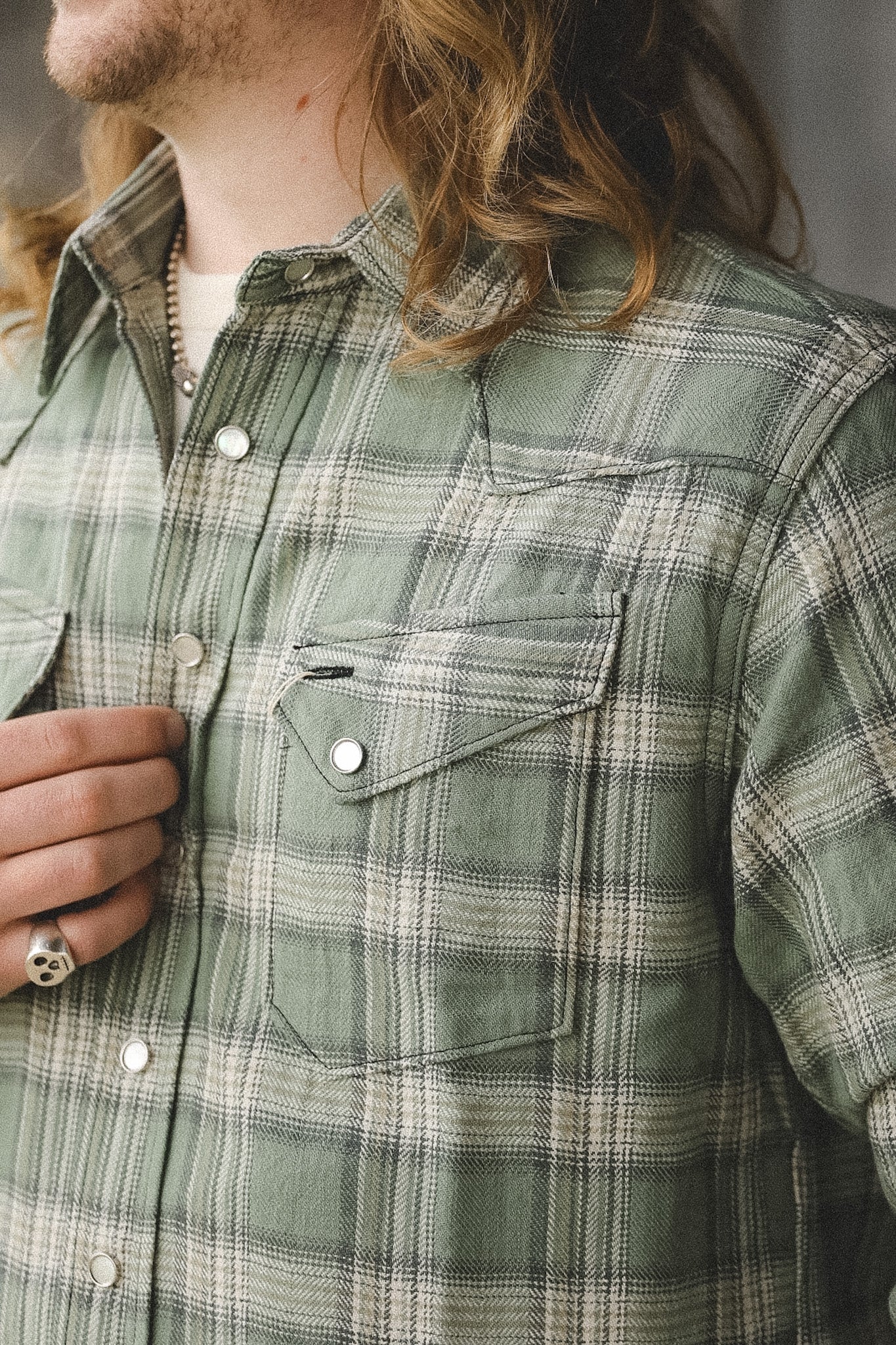 Green plaid shirt worn by a person with a neutral background