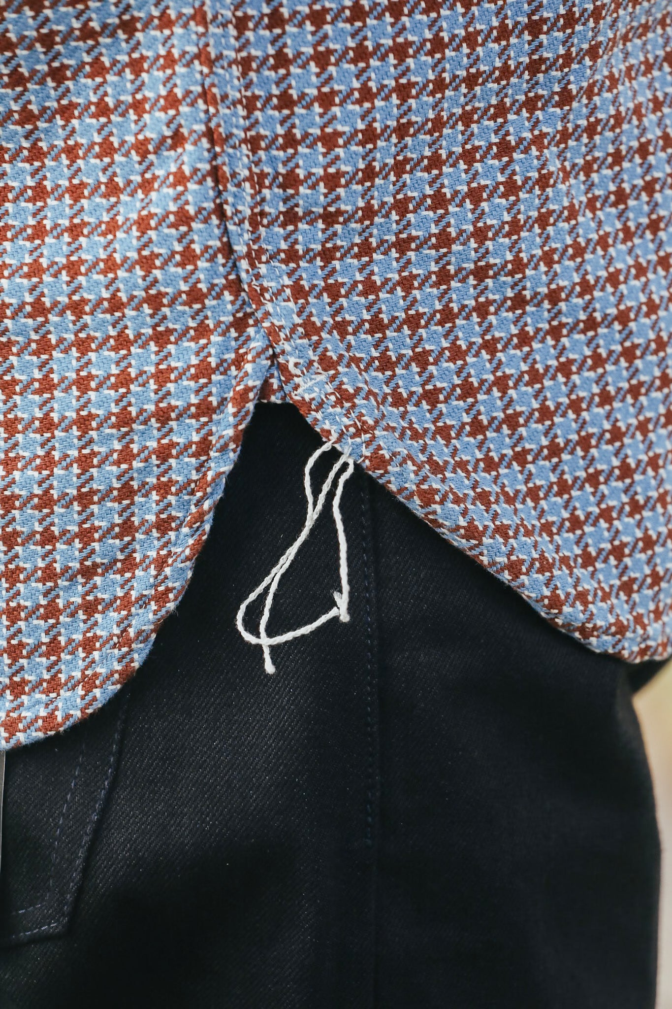 Close-up of a patterned fabric with red and blue checkered design on a black background.