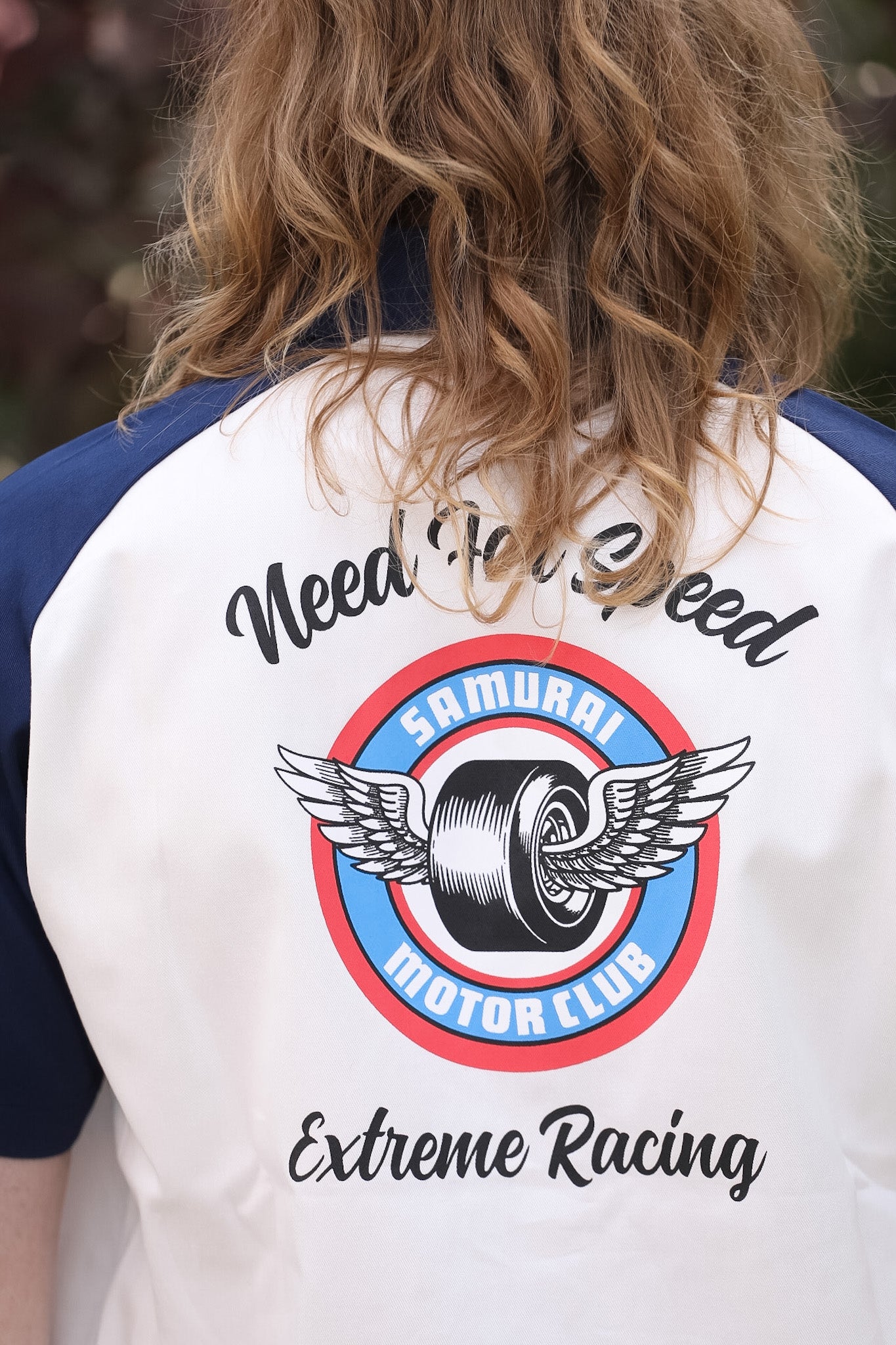 Person wearing a jacket with 'Samurai Motor Club' logo and text on the back.