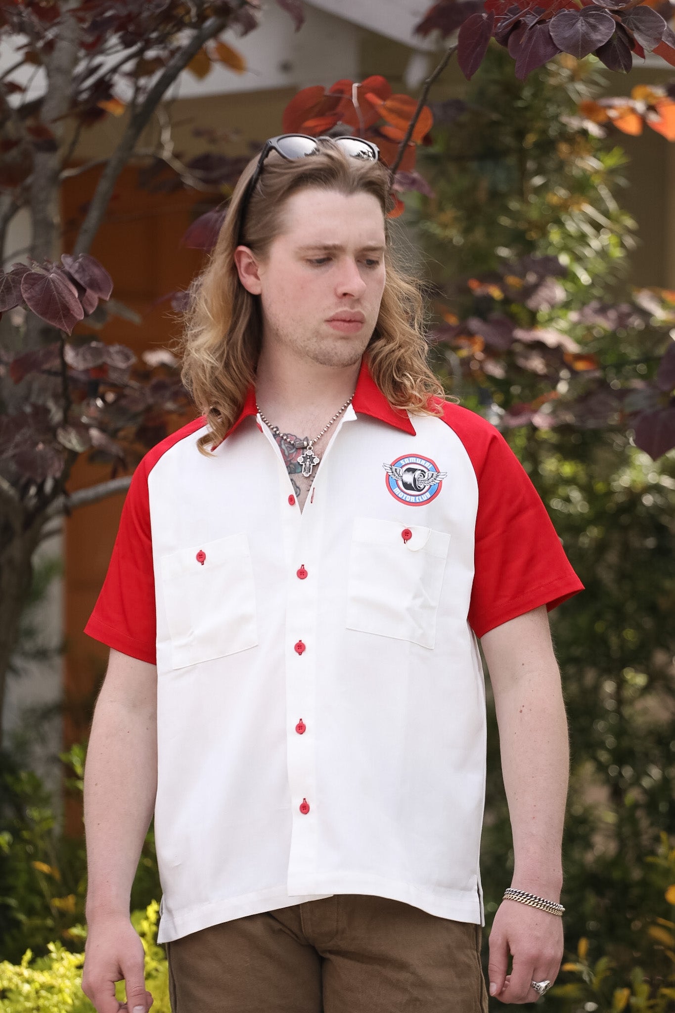 Person wearing a red and white shirt with a logo outdoors