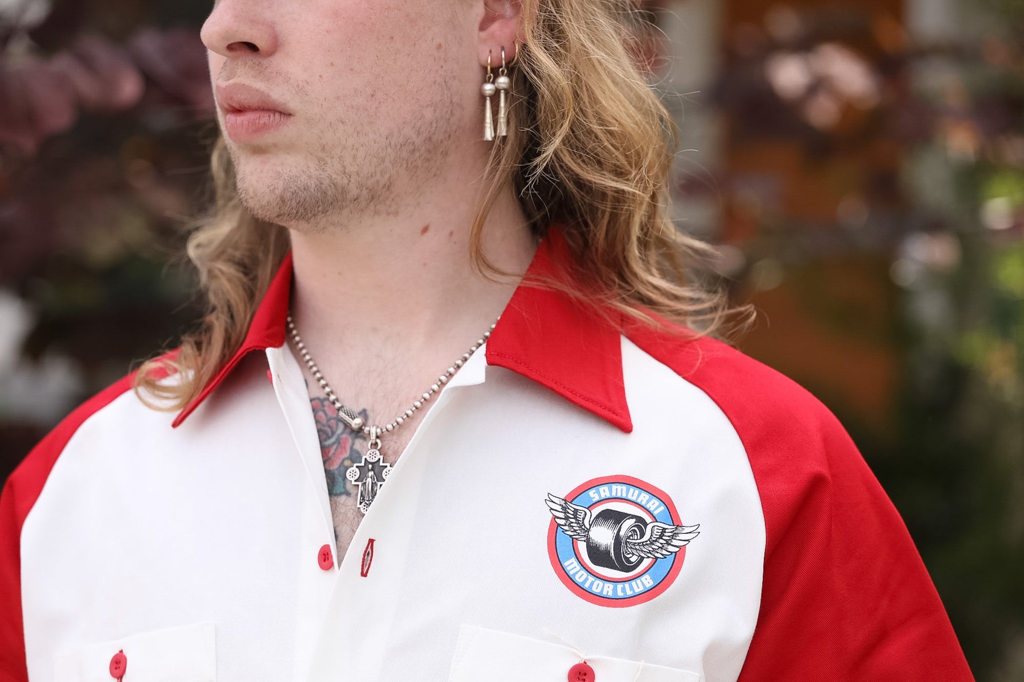 Person wearing a red and white jacket with a logo, blurred background