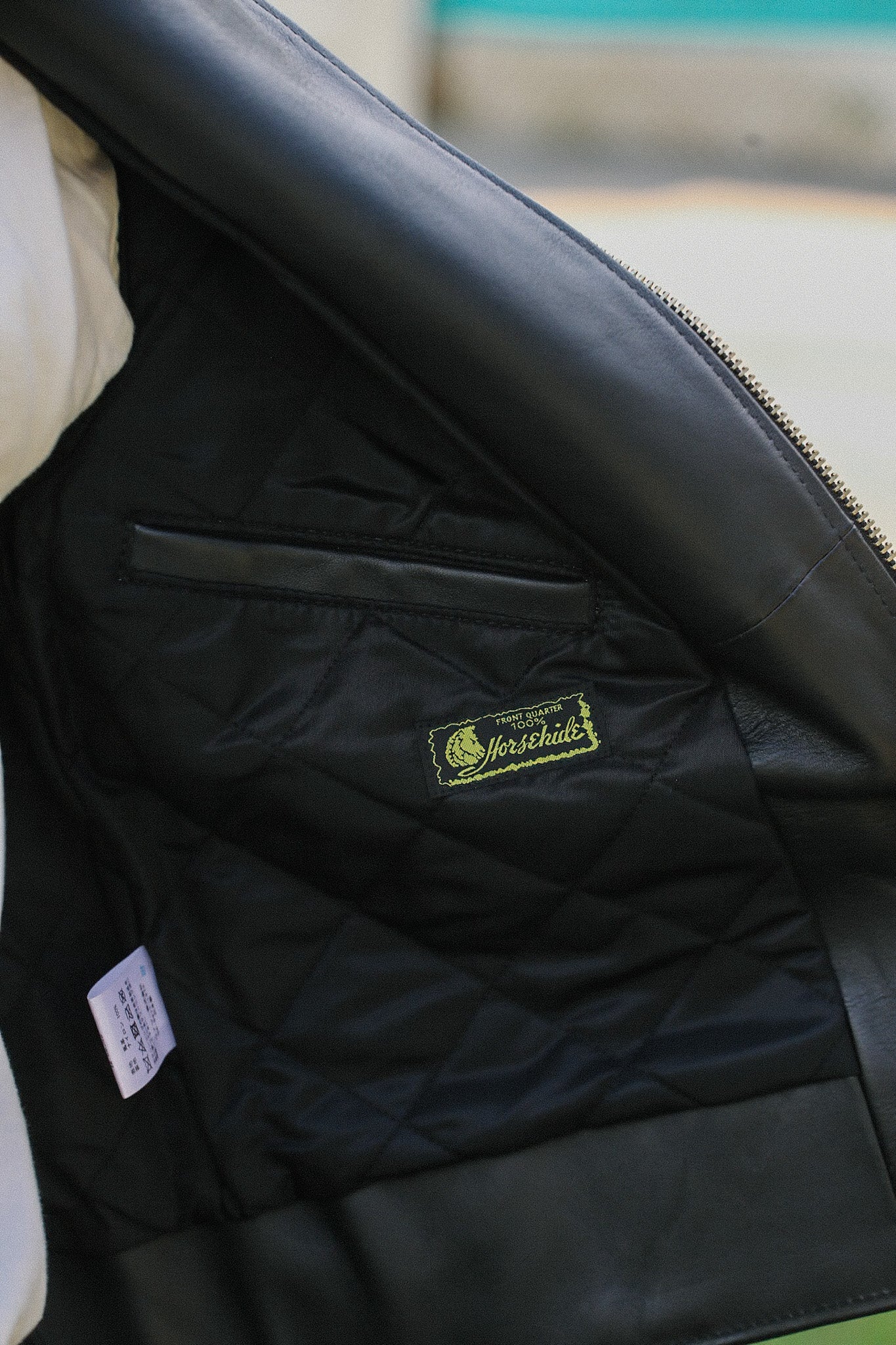 Interior of black Sumi Dyed Double Riders Jacket showing quilted lining and 100% horsehide label