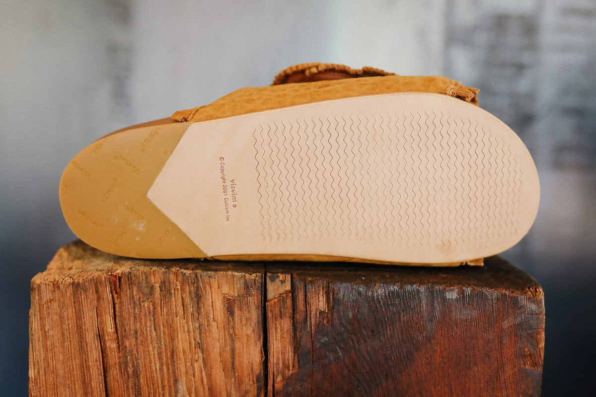 Brown sandal on a wooden block with a blurred background