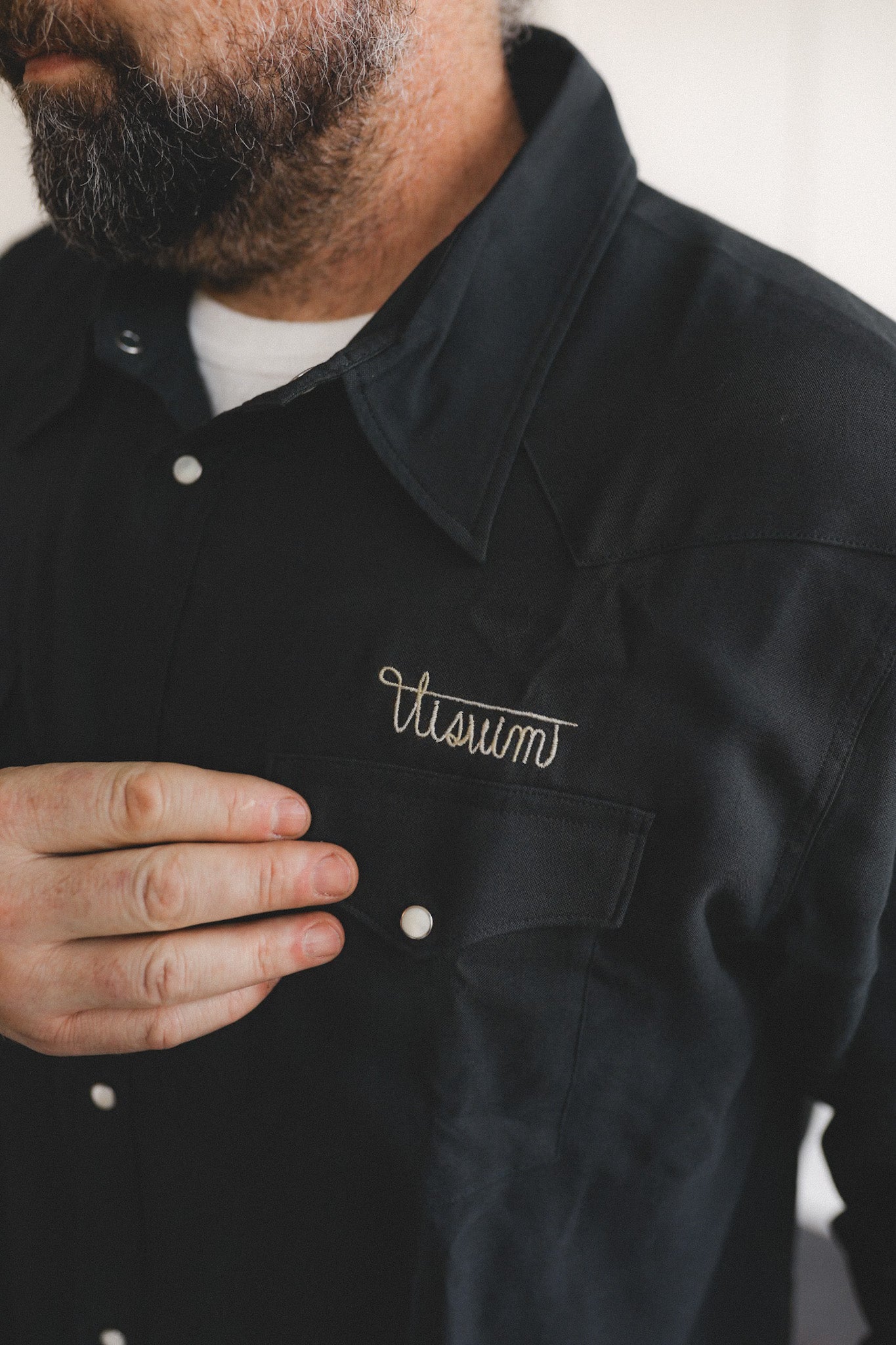Person wearing a black jacket with 'Vitam' logo on a blurred background