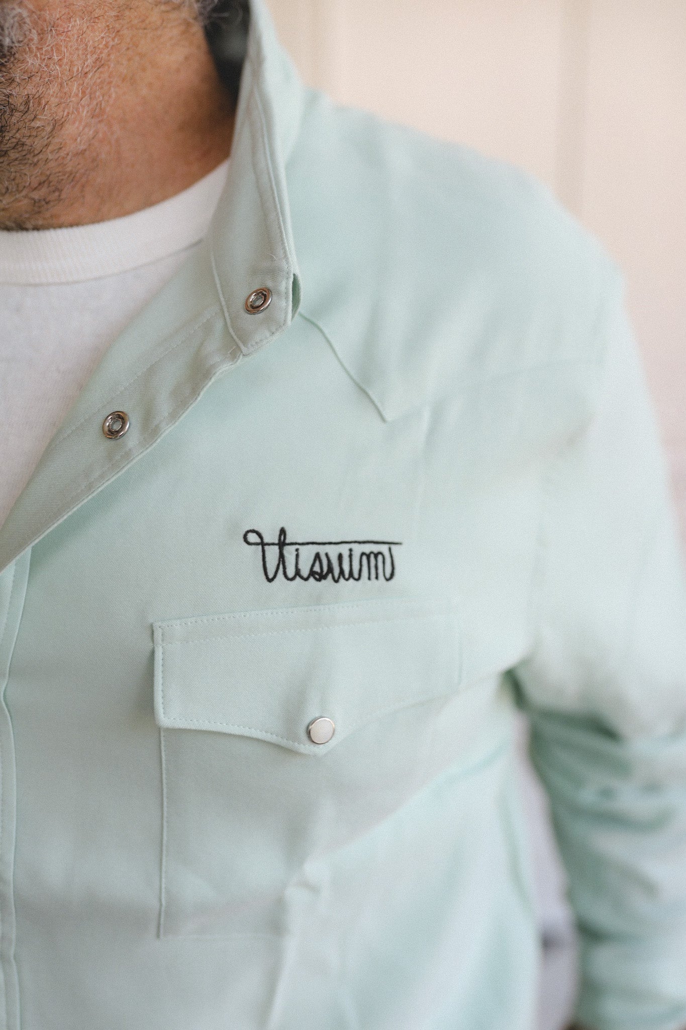 Light green shirt with 'Vitium' embroidery on a neutral background