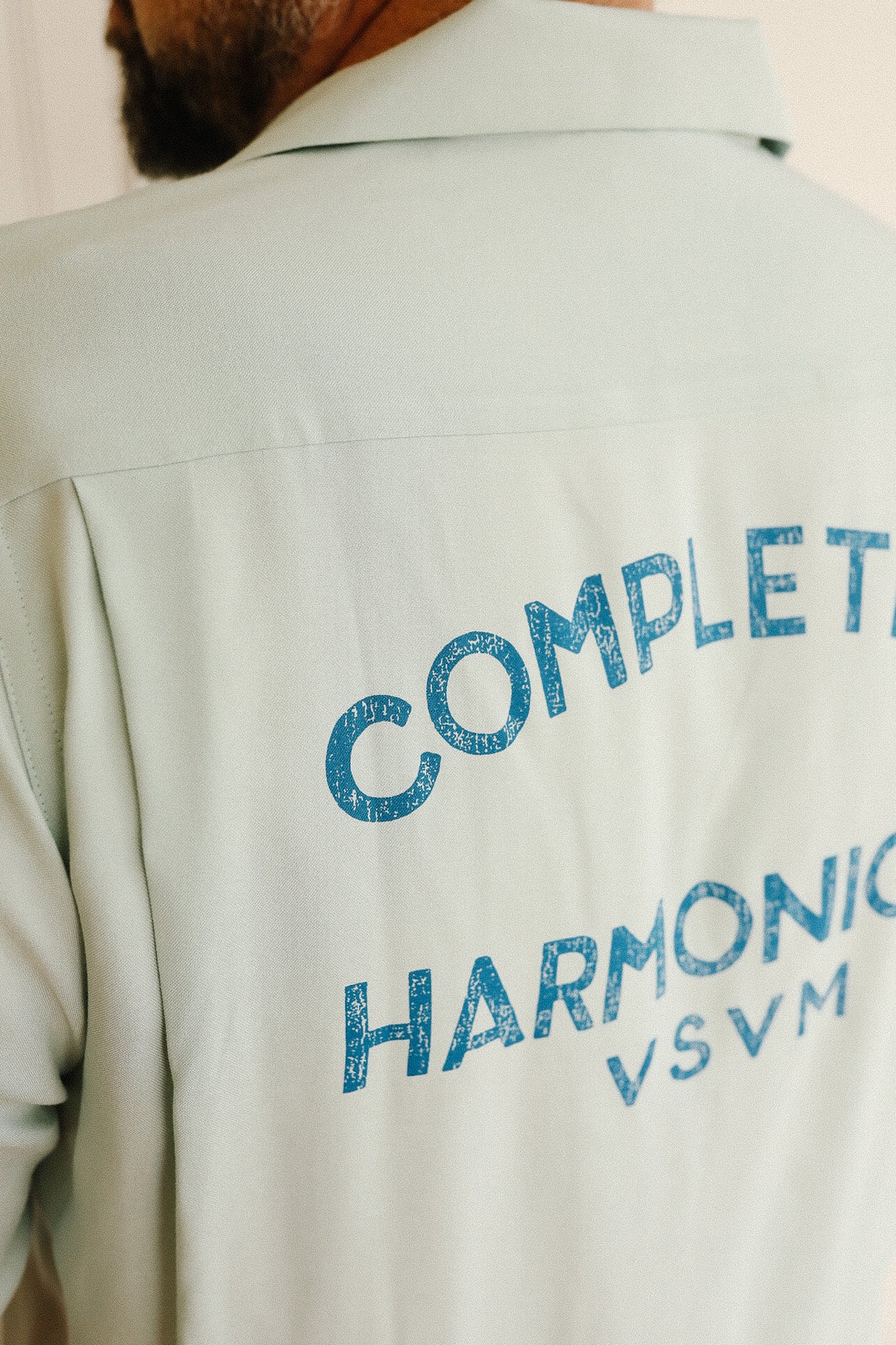 Light-colored shirt with blue text on the back