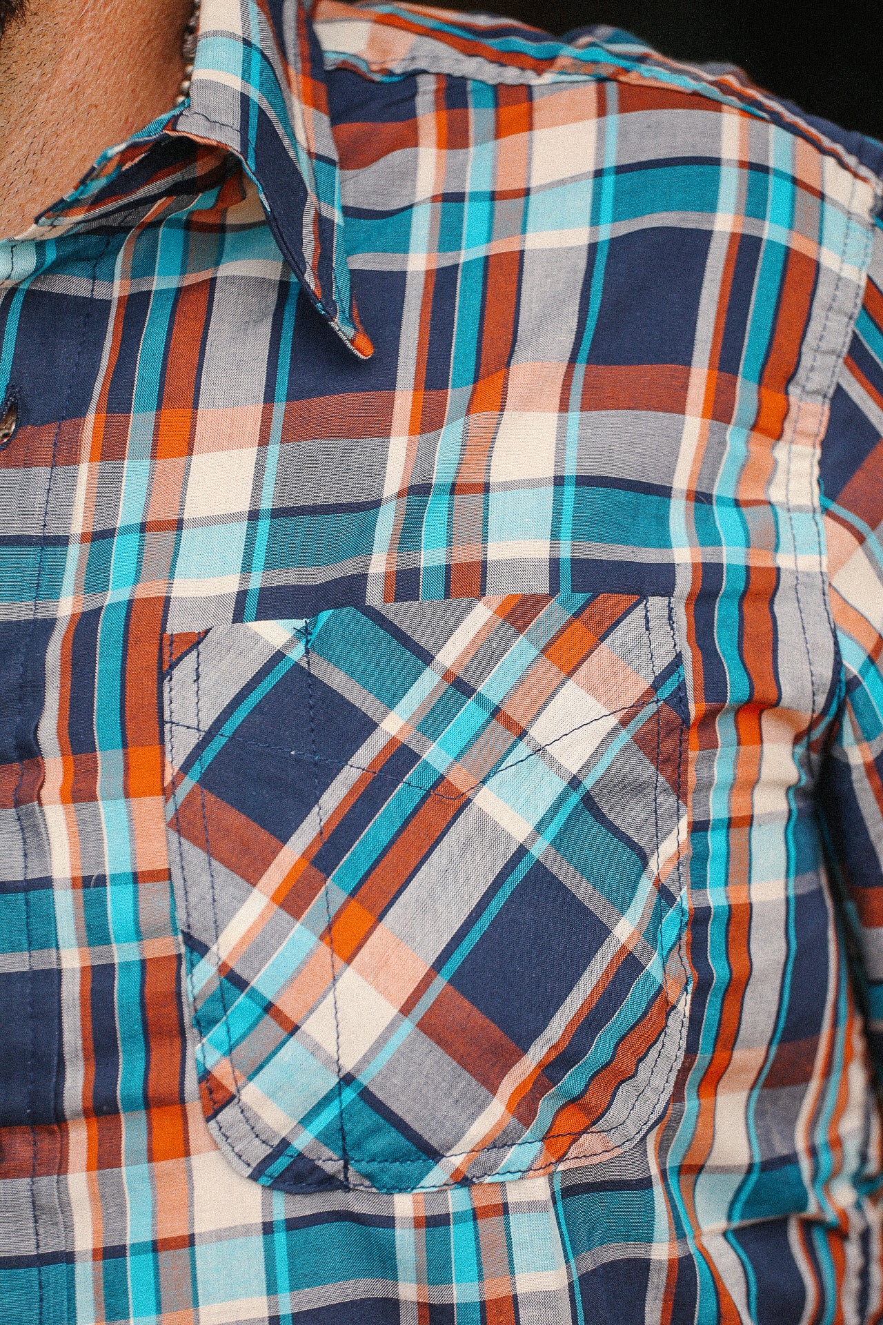 Close-up of turquoise, orange, and navy plaid Tellason short sleeve shirt with chest pocket at Iron Shop Provisions