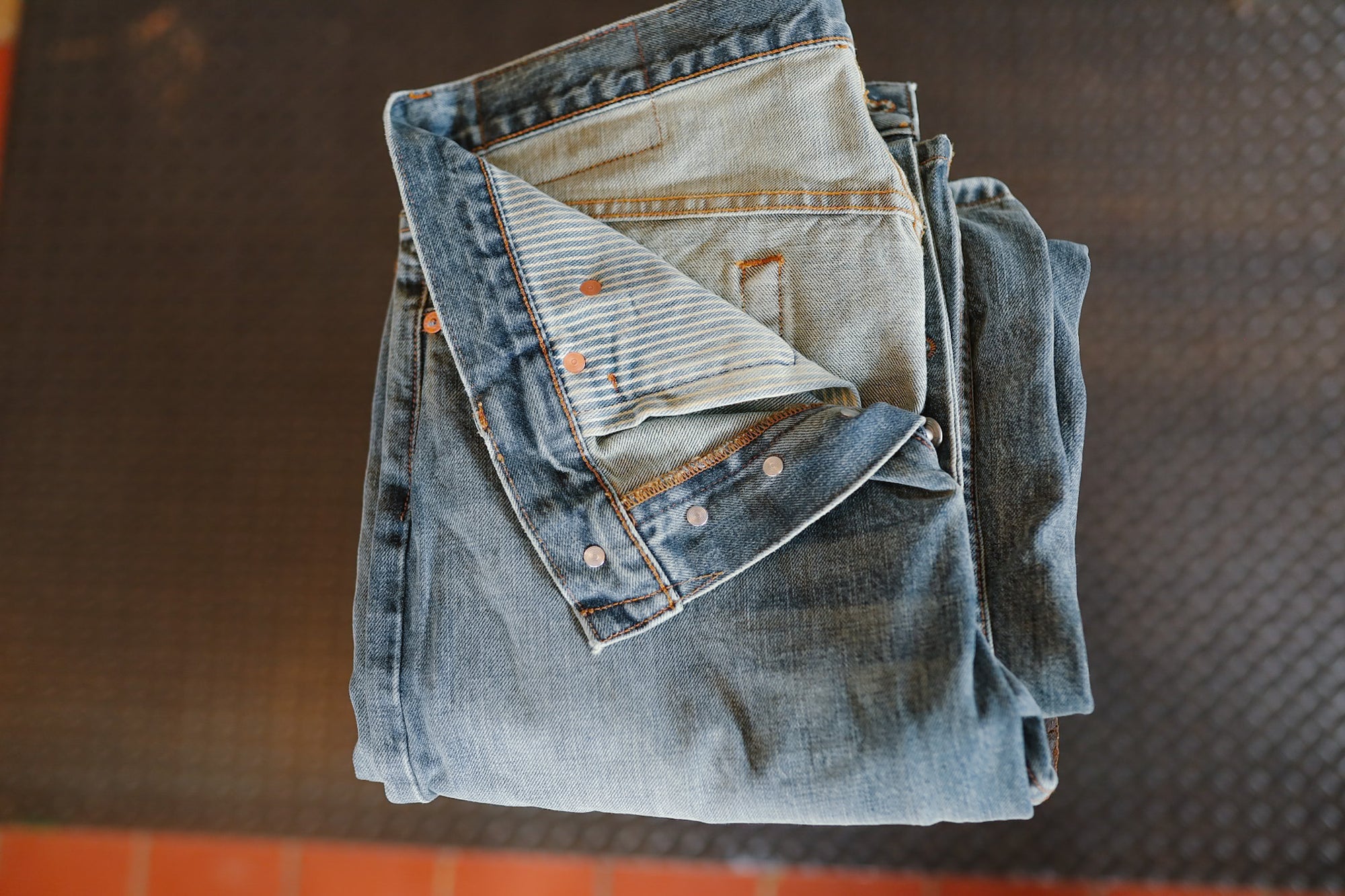 Folded denim jeans on a dark textured surface