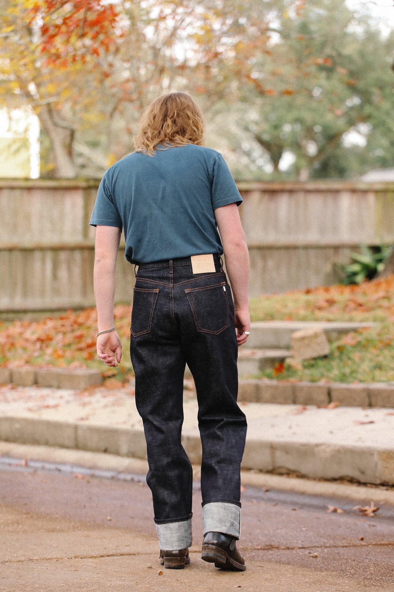 Person wearing dark Indigo 20oz double slub denim wide straight jeans with cuffs walking outdoors in autumn setting