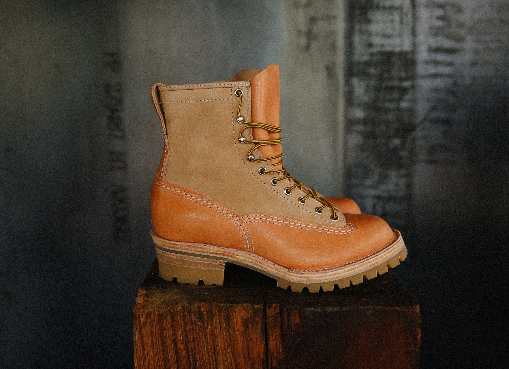 Natural burlap and tan leather Wesco Jobmaster work boot on wooden block with industrial background