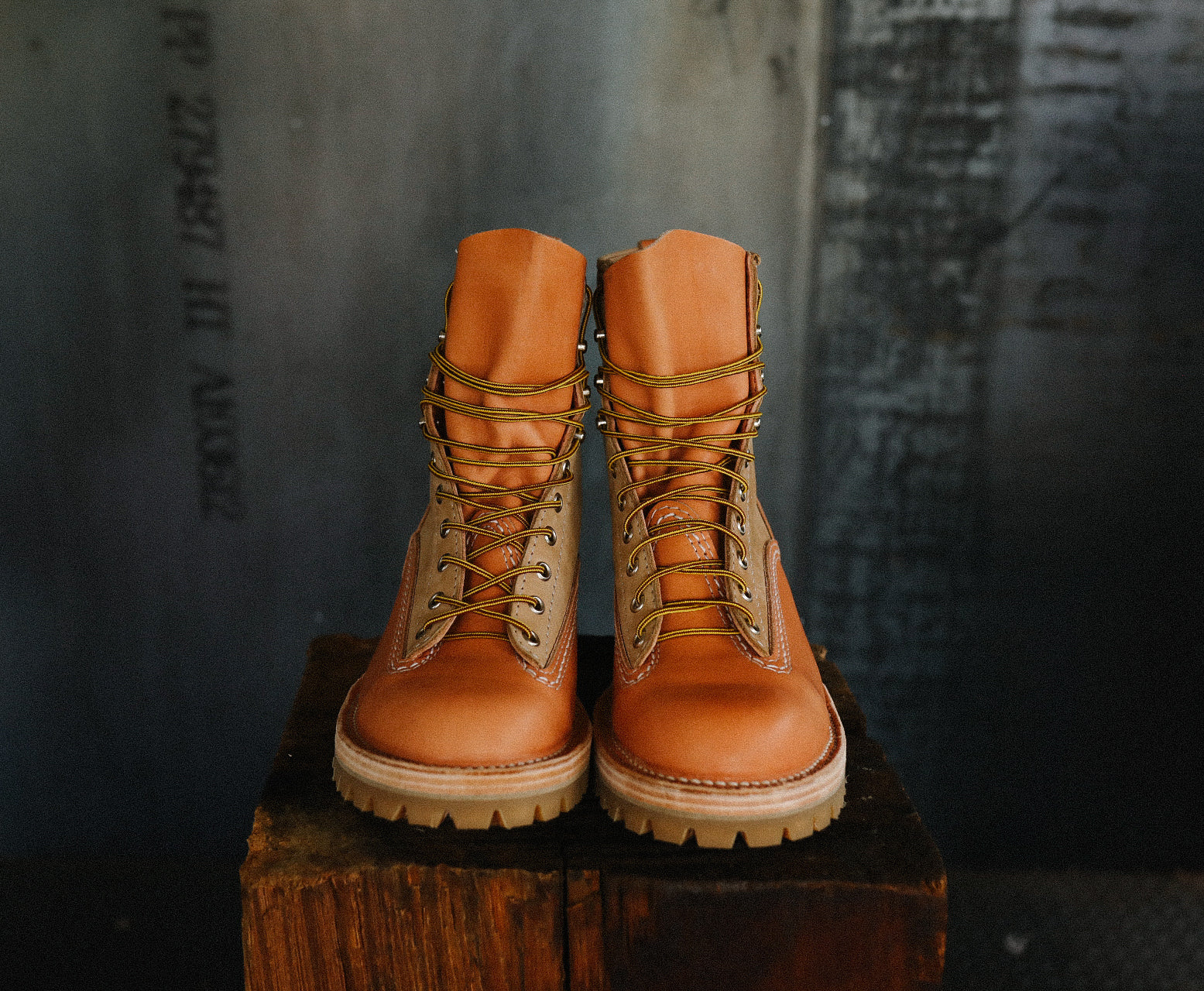 Pair of natural burlap Wesco Jobmaster leather boots with rugged soles displayed on wooden block