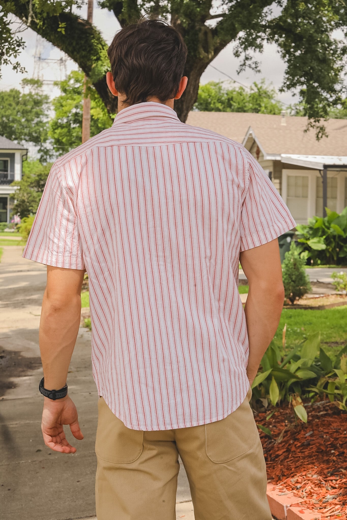 Person wearing a red and white striped shirt in a suburban setting
