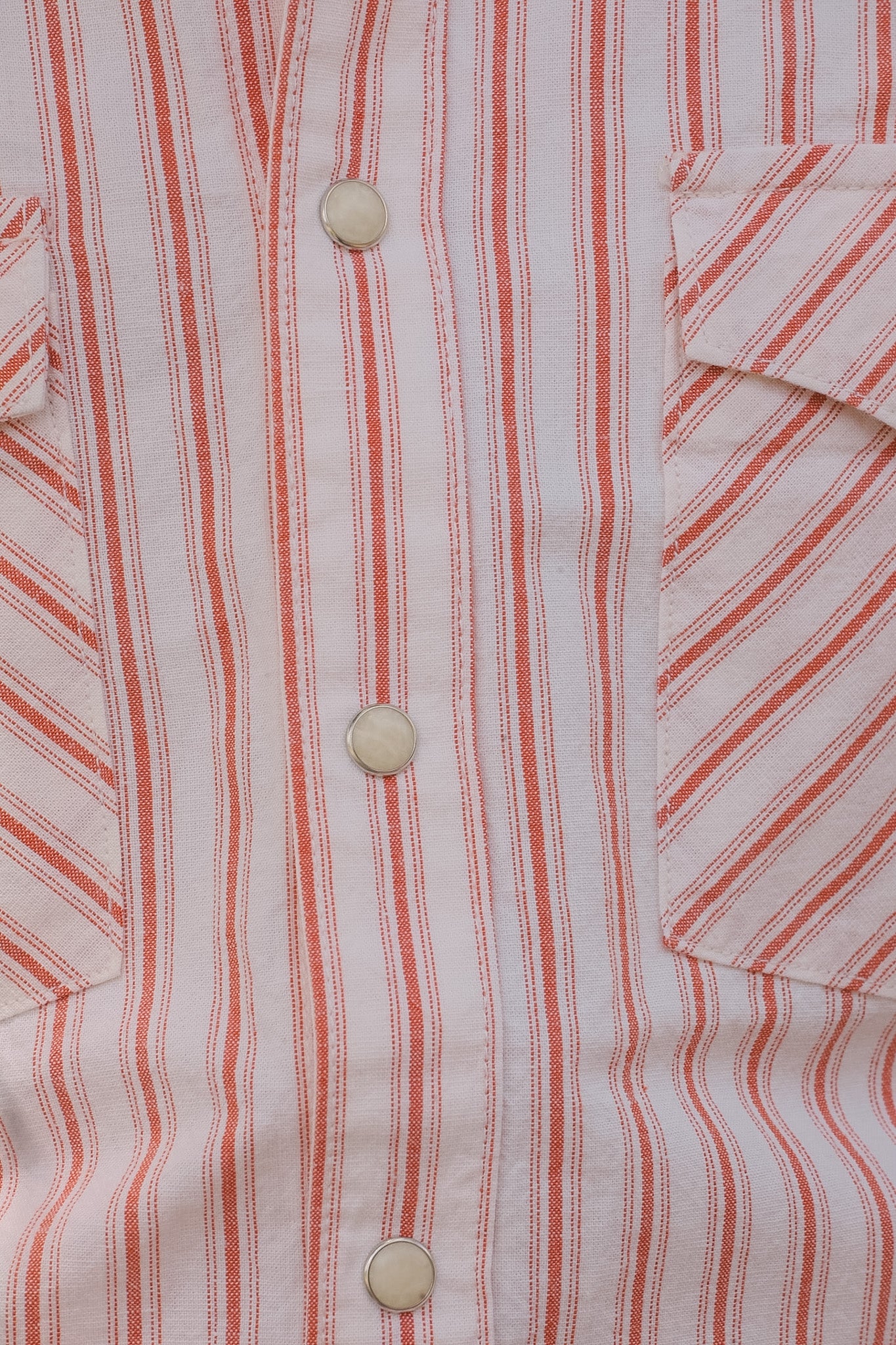 Close-up of a red and white striped shirt with buttons.