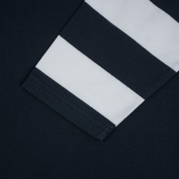 Close-up of navy blue fabric with white and navy striped sleeve detail from Iron Shop Provisions apparel