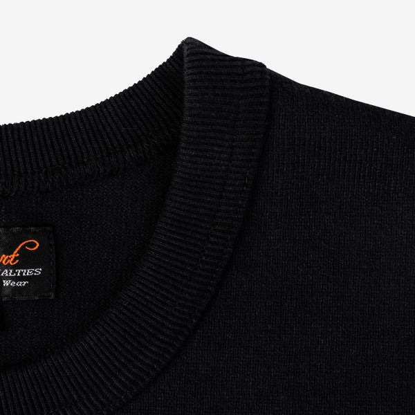 Close-up of black crew neck sweater collar with ribbed texture and fabric label inside