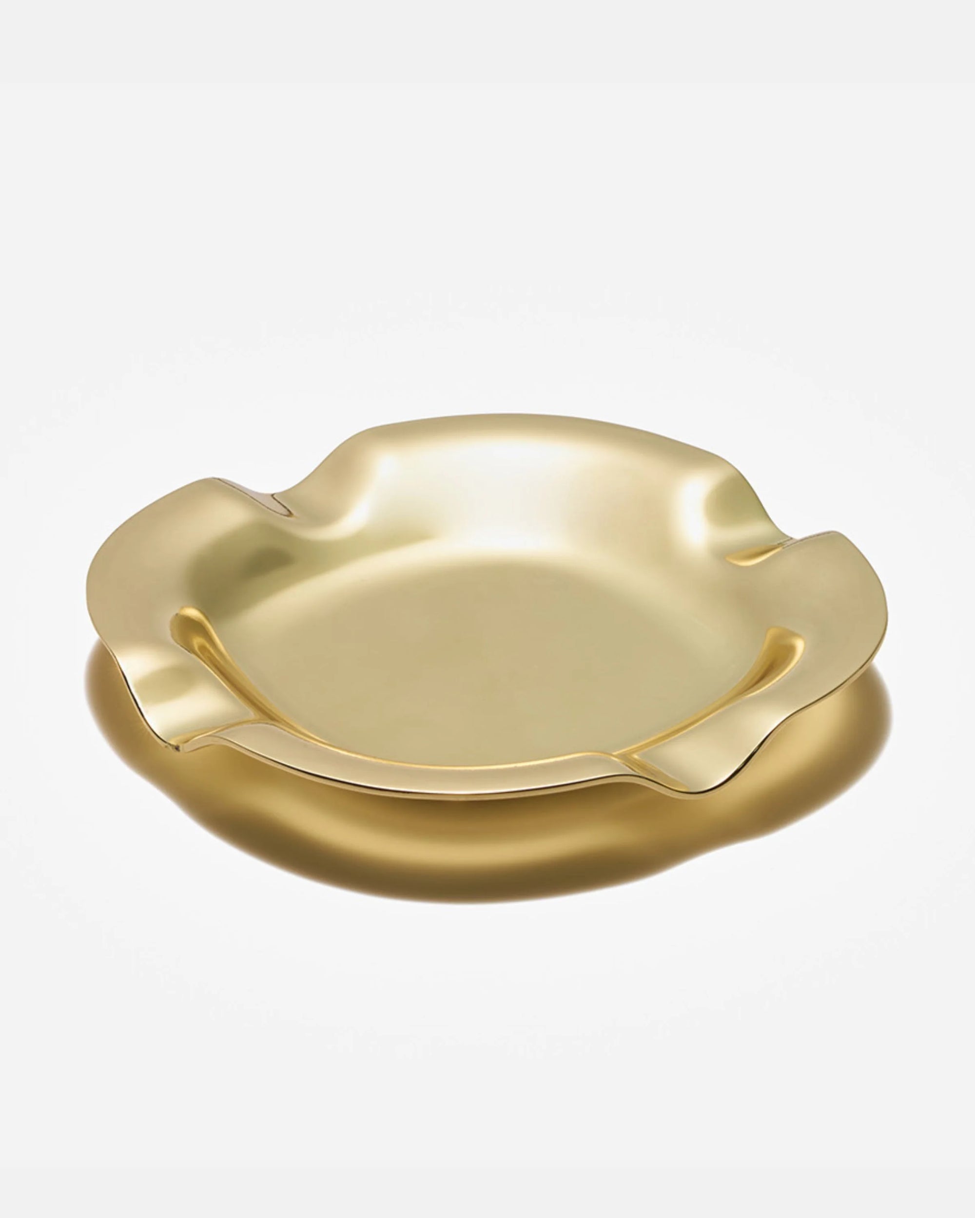 Castro brass tray with wavy edges on white background, elegant vintage metal decorative plate