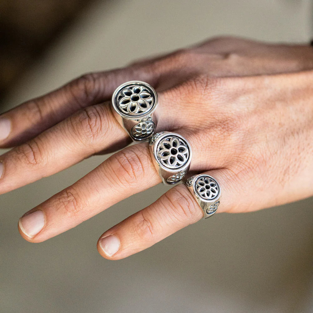 Hand wearing three silver floral design rings from Iron Shop Provisions on fingers