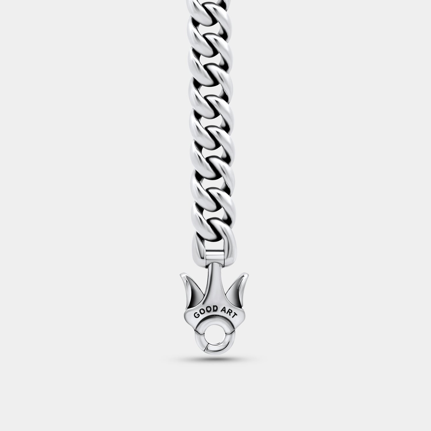 Close-up of shiny silver Cuban link chain with Good Art engraved clasp on gray background