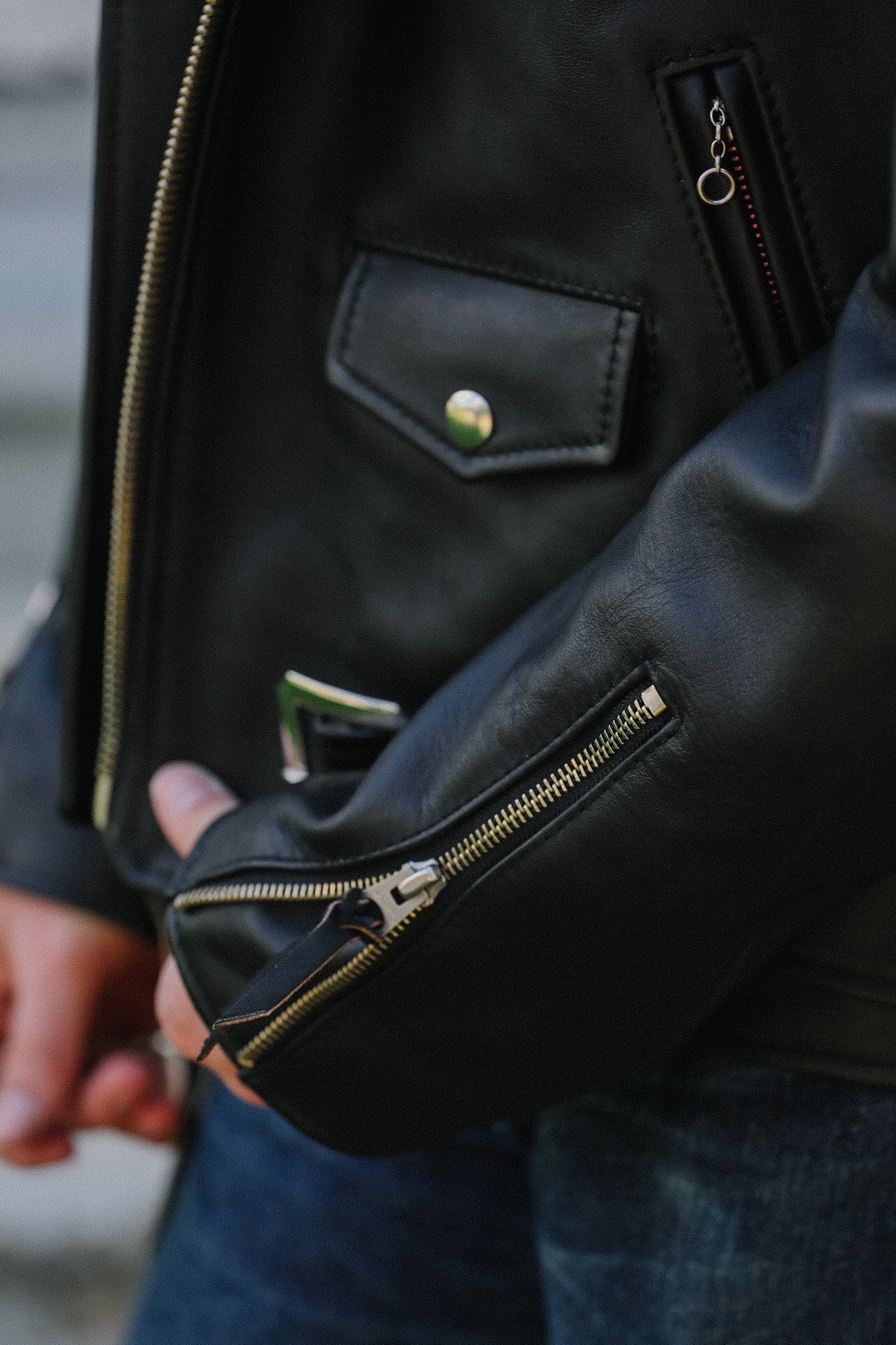Close-up of black saddle dyed horsehide leather double riders jacket with zipper and snap pocket detail