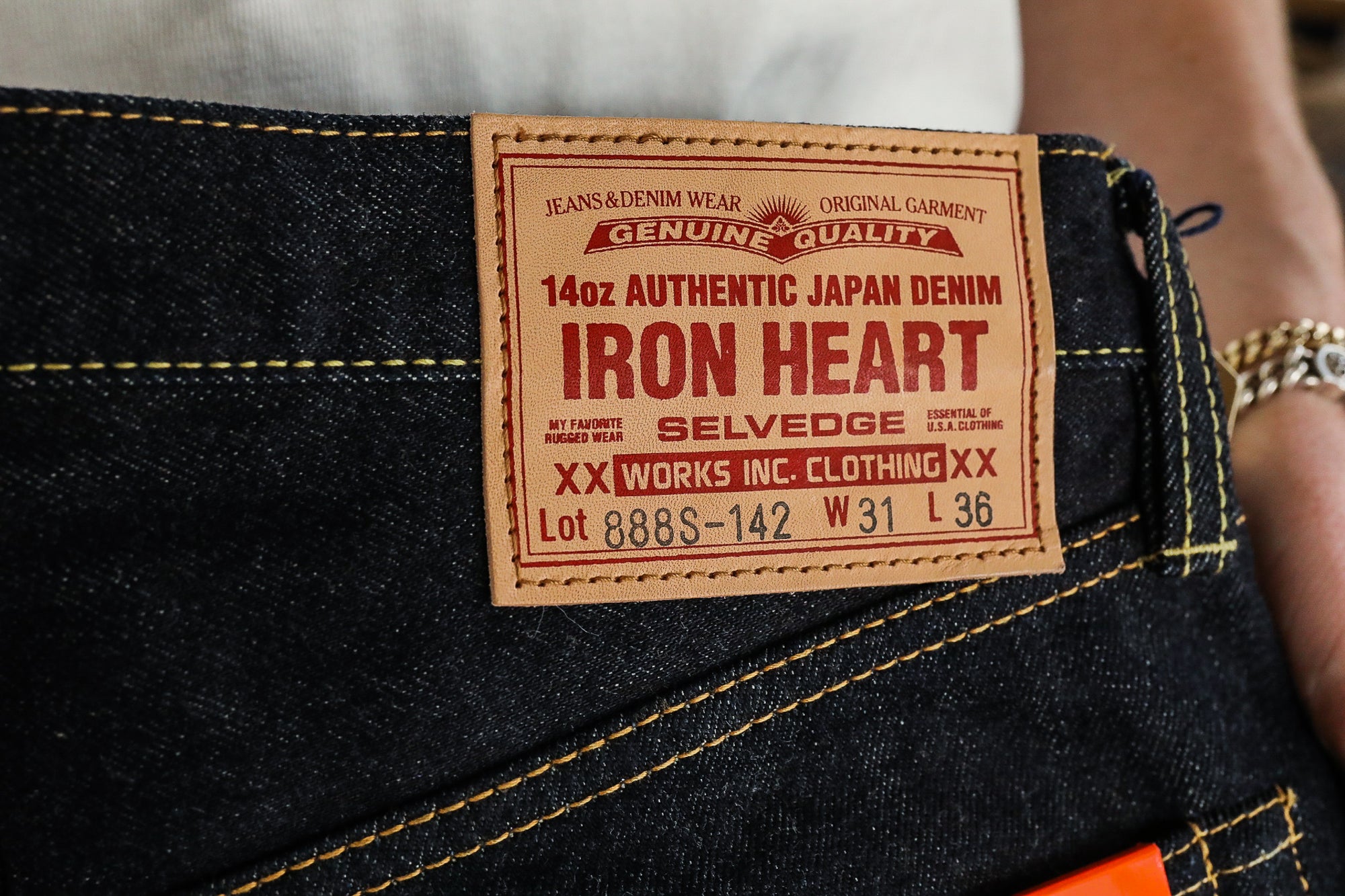 Close-up of Iron Heart 14oz Authentic Japan Denim jeans with tan leather patch and yellow stitching