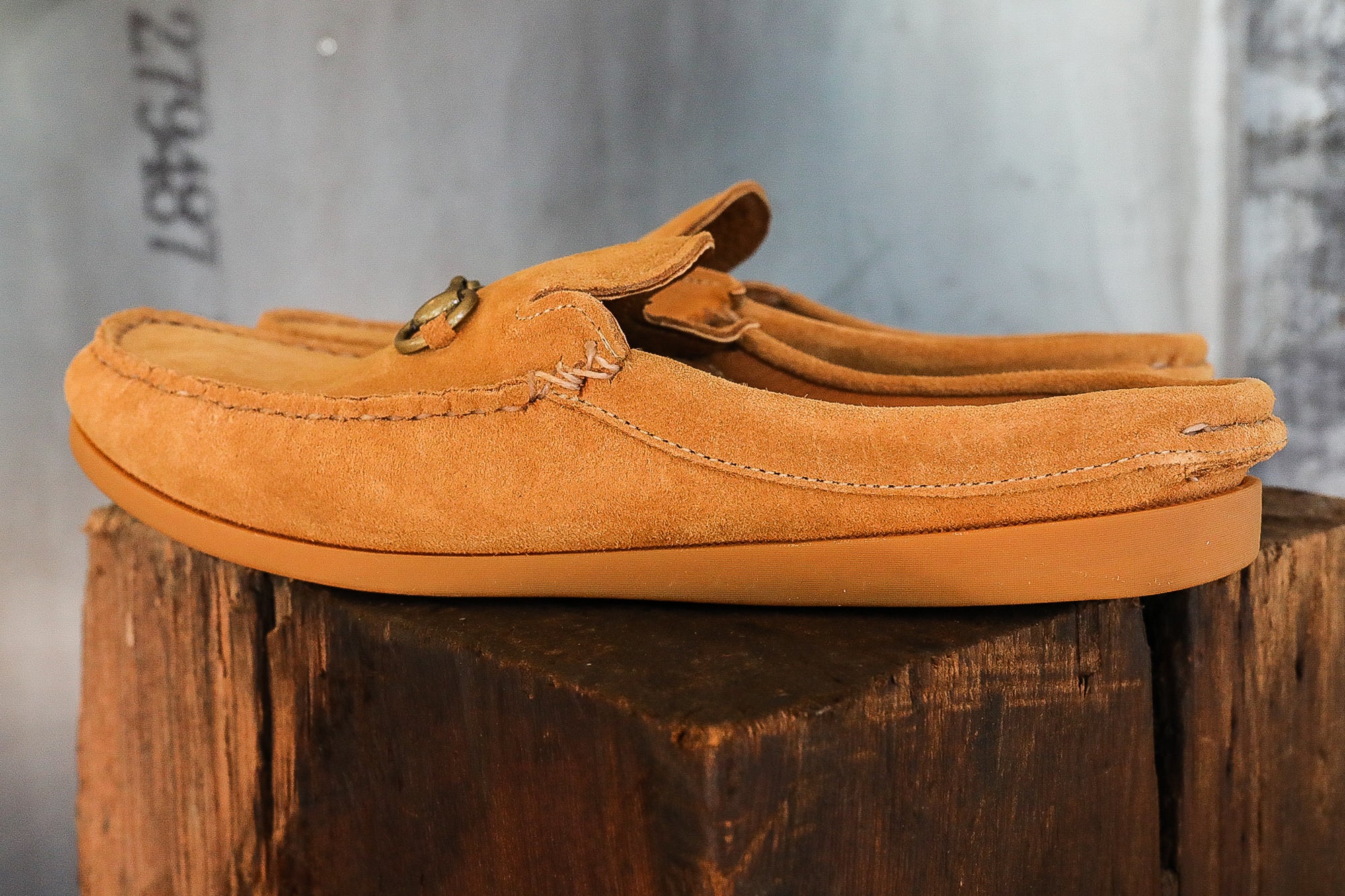 Tan suede slip-on loafers with metal bit detail on wooden surface at Iron Shop Provisions