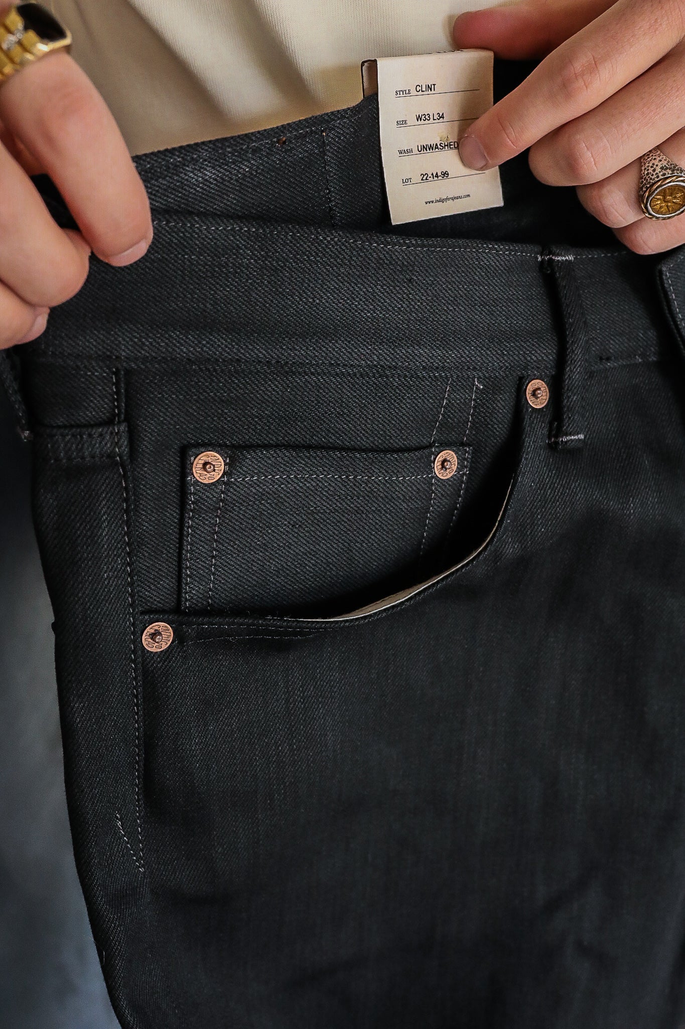Close-up of black Iron Shop Provisions Clint jeans with copper rivets and size tag W33 L34 unwashed