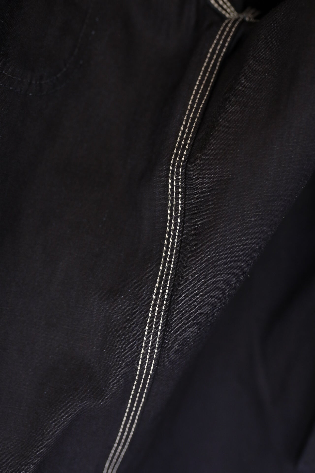 Close-up of black durable fabric with white triple stitching from Iron Shop Provisions clothing