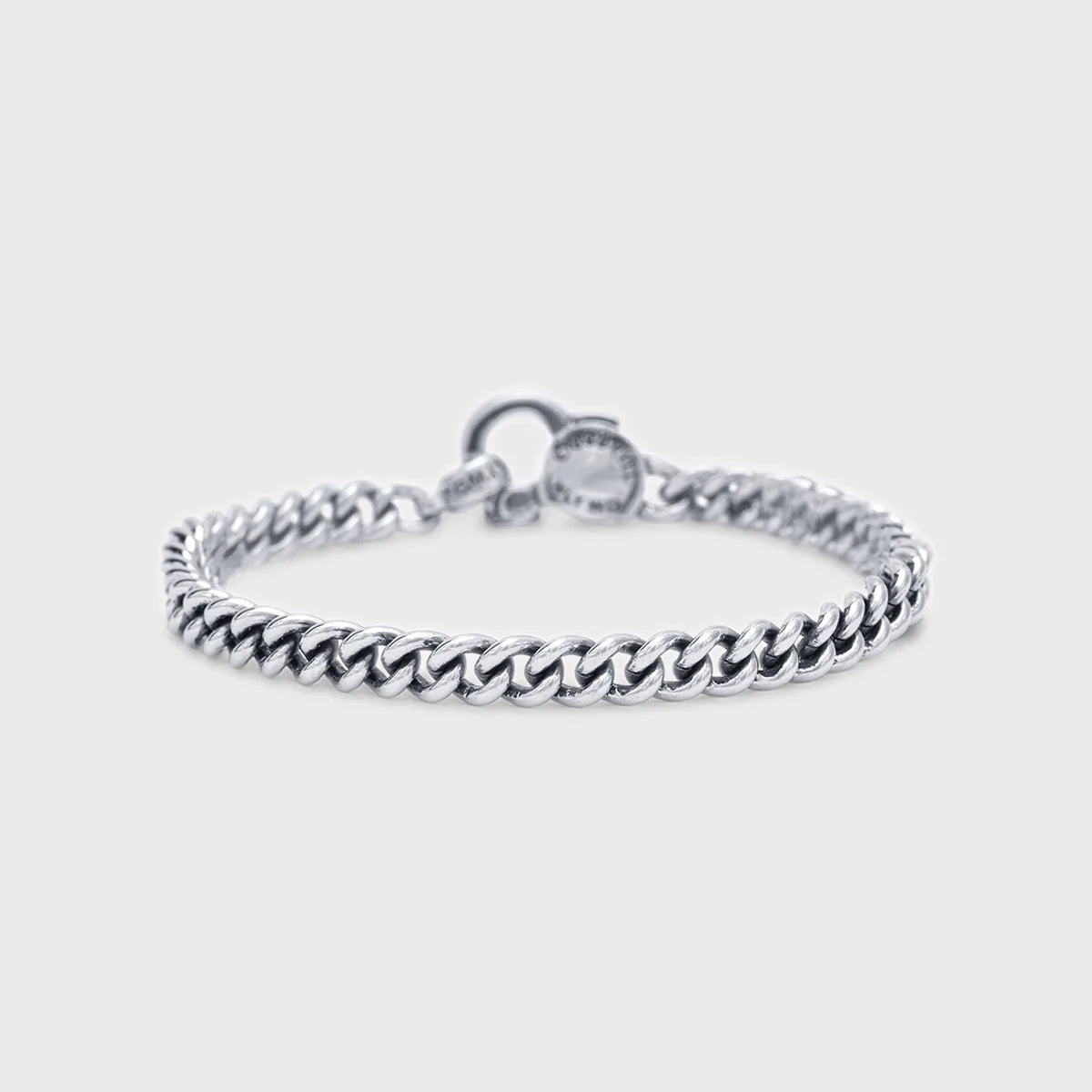 Sterling silver curb chain bracelet with a round clasp, displayed on a light gray background