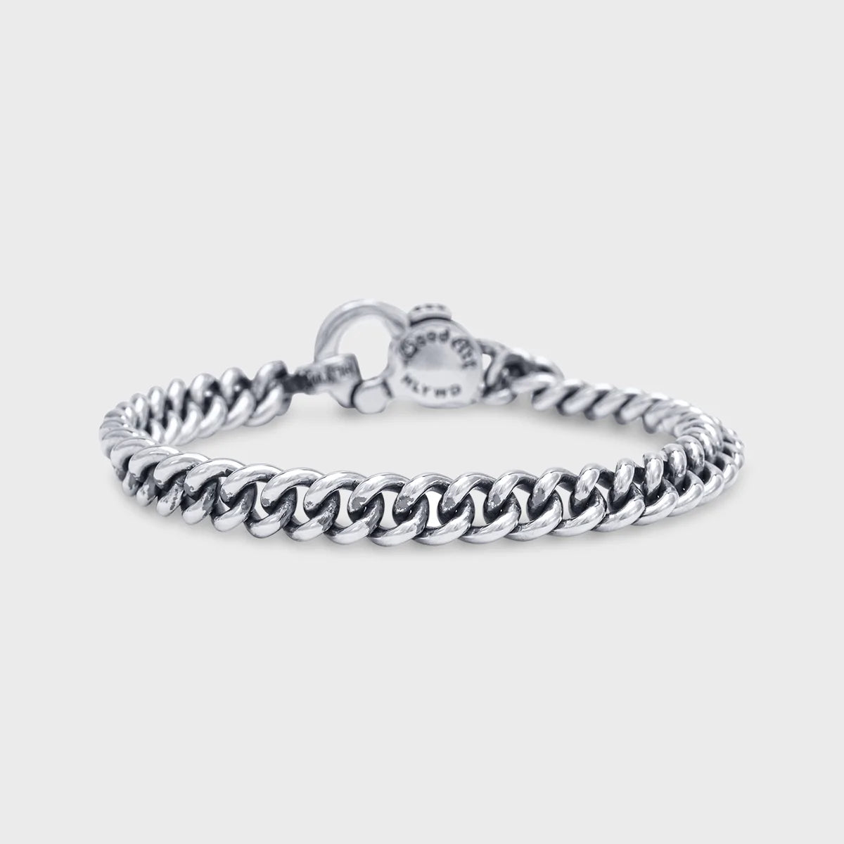 Sterling silver curb chain bracelet with polished links on a plain light background